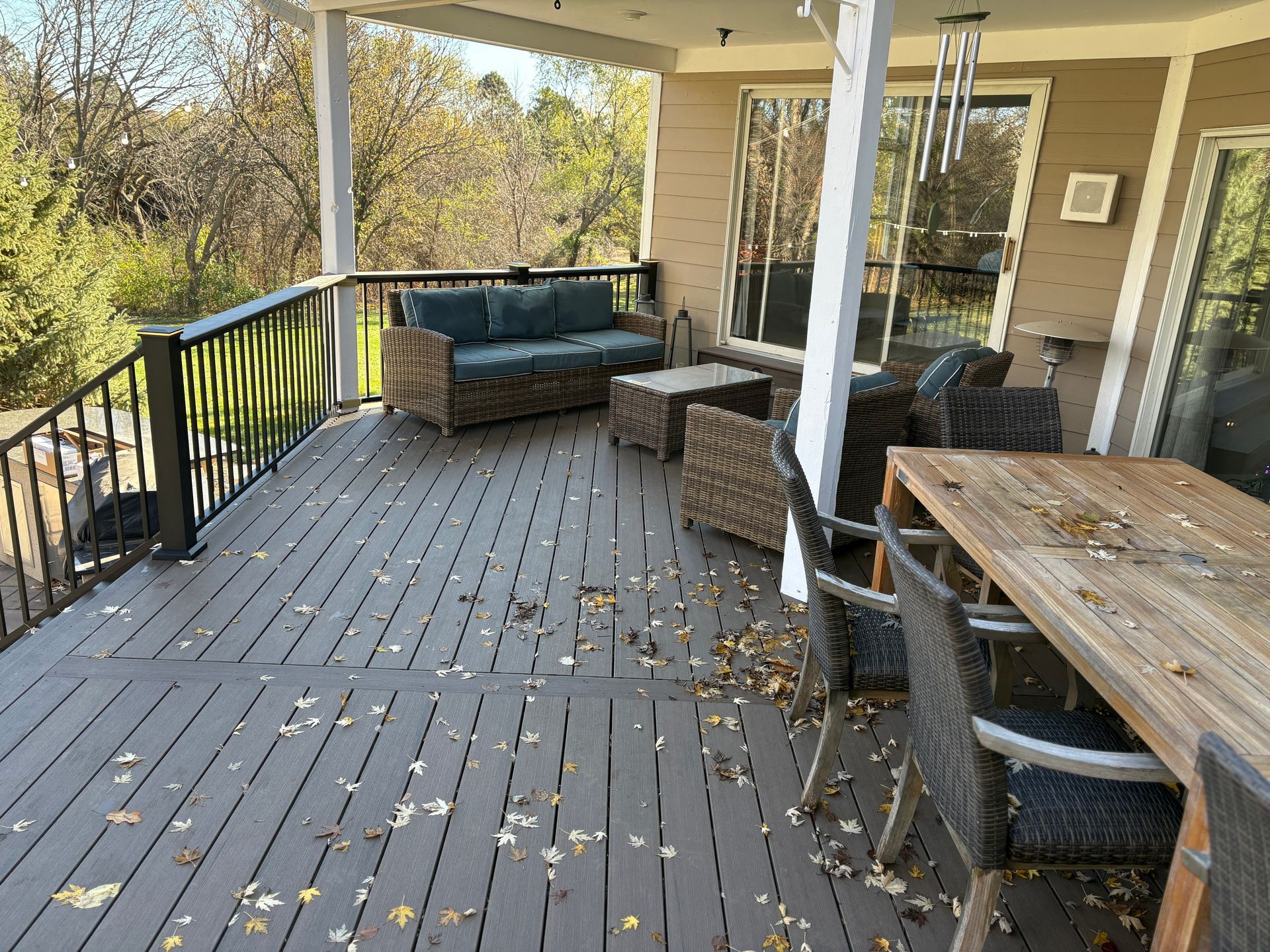 A deck with a couch , chairs , and a table.