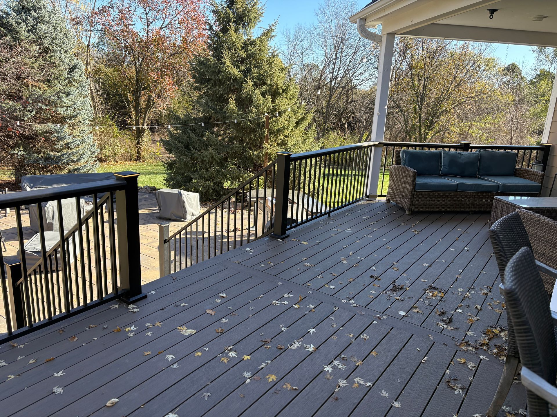 A large deck with a couch and chairs on it.
