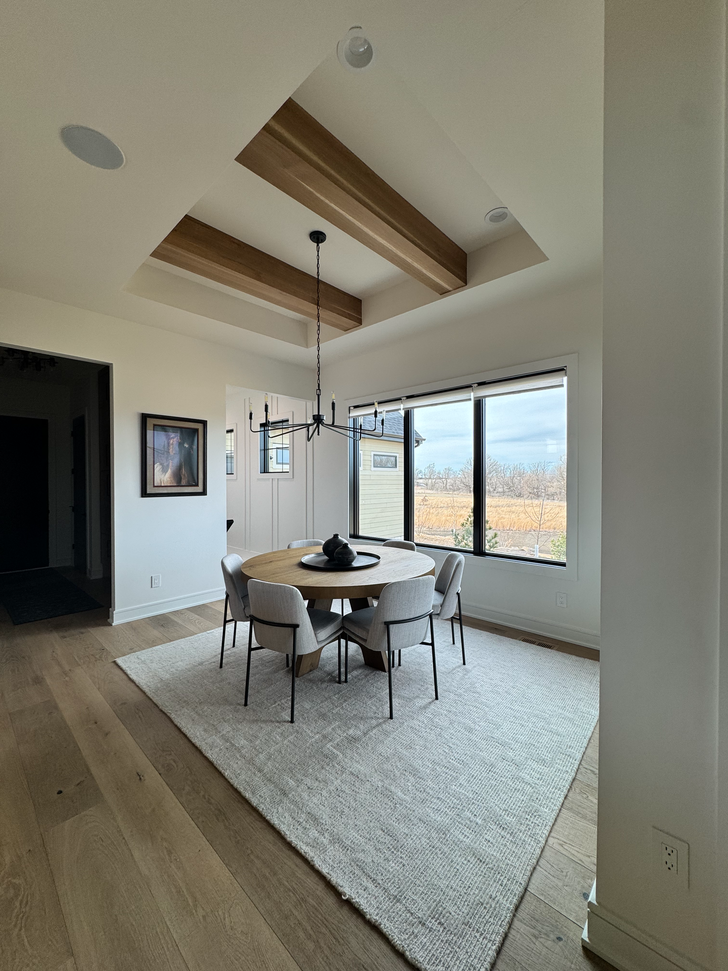 A dining room with a round table and chairs and a rug.