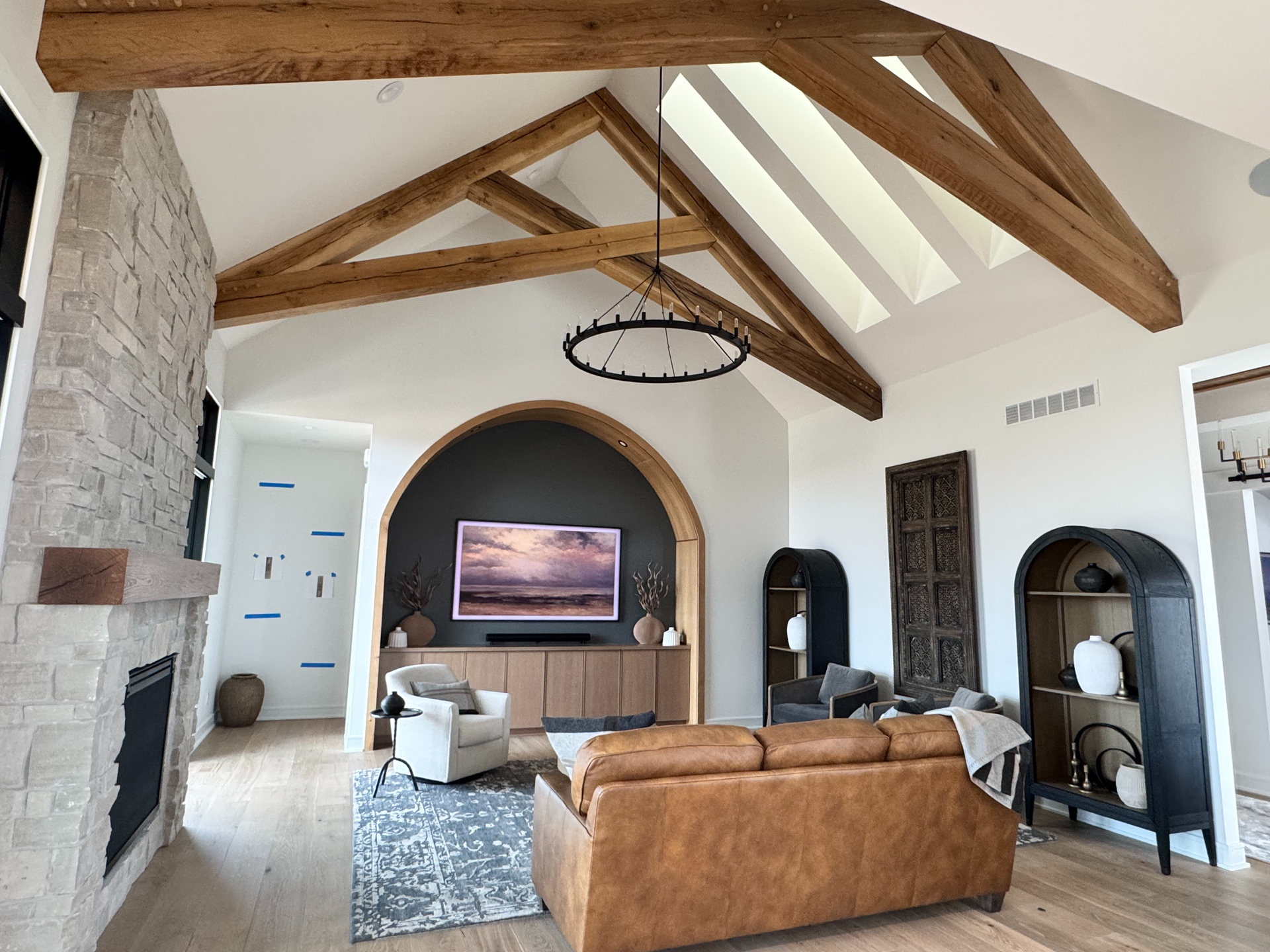 A living room with a couch , chairs , fireplace and television.
