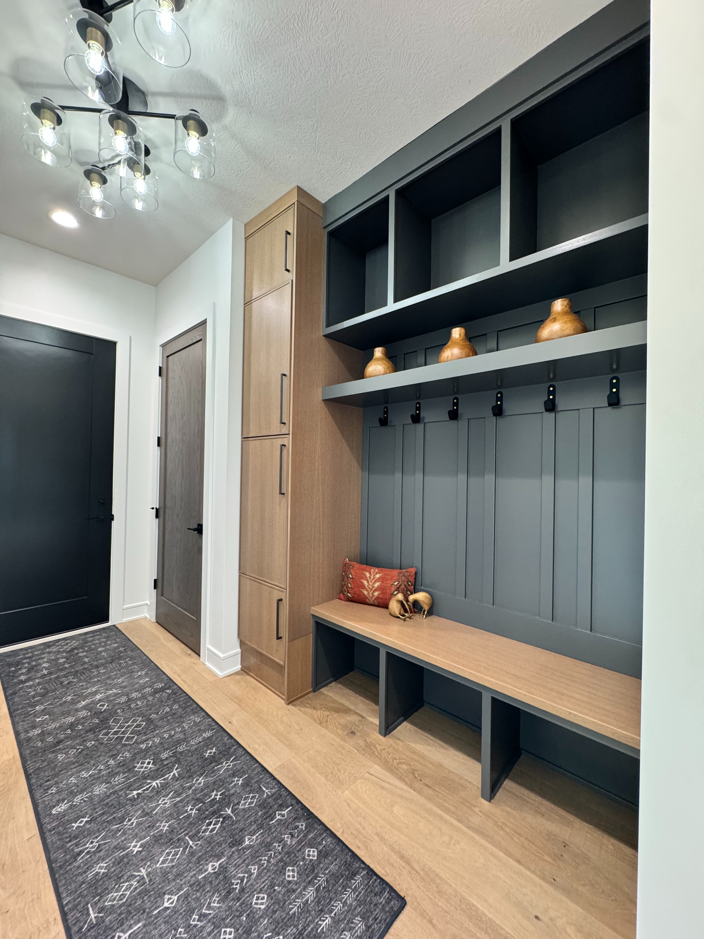 A hallway with a bench and shelves in a house.