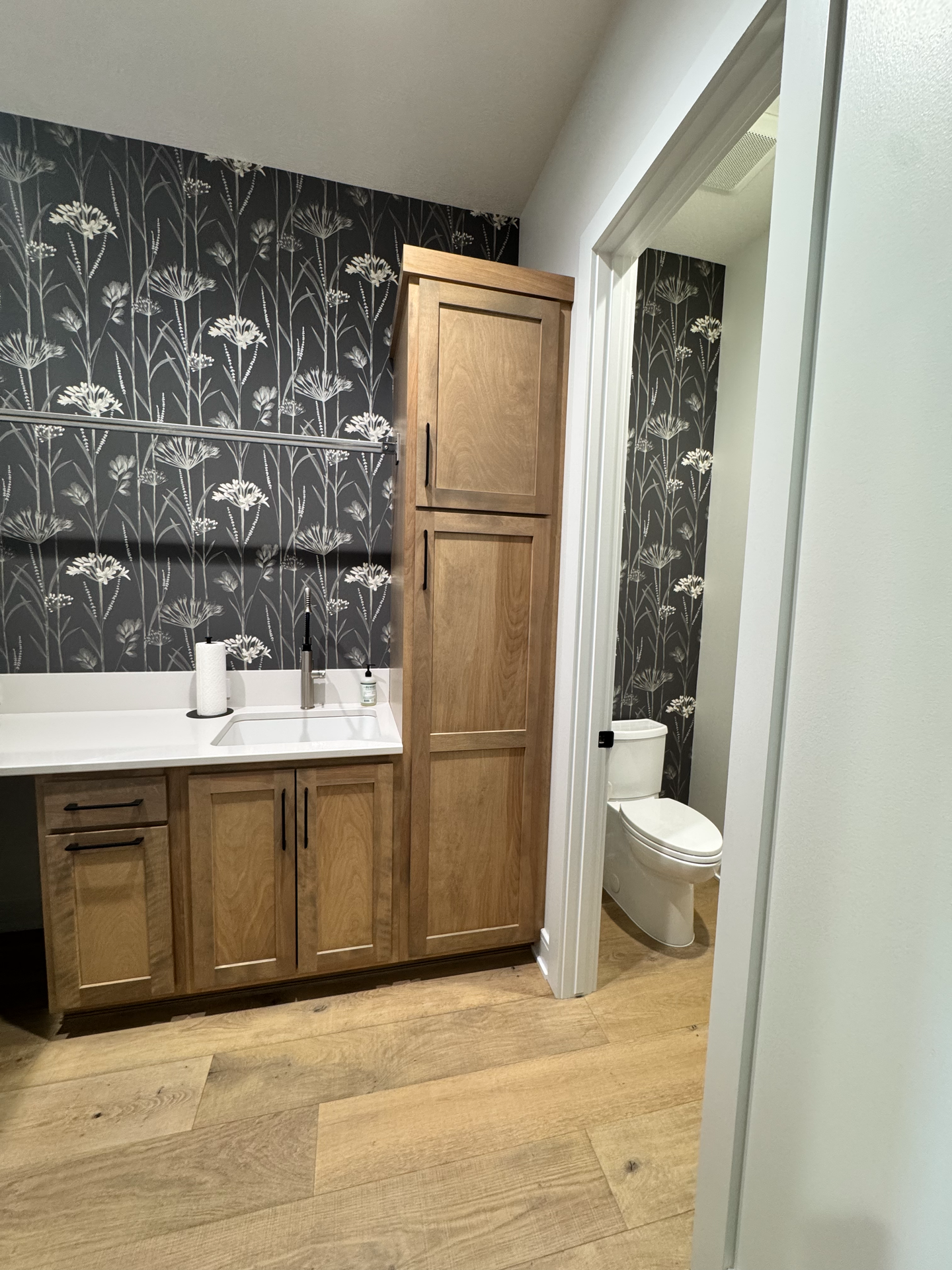 A bathroom with a sink , toilet and cabinets.