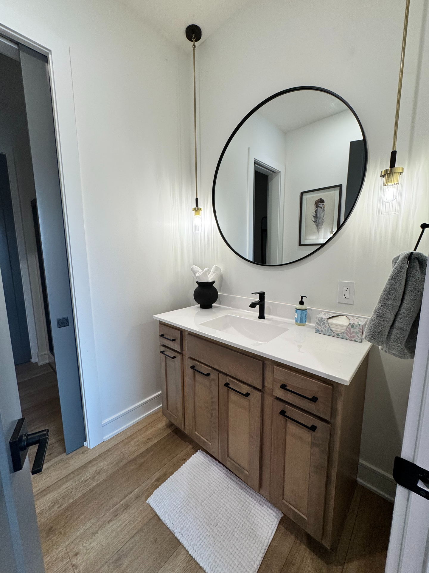 A bathroom with a sink , mirror and wooden cabinets.