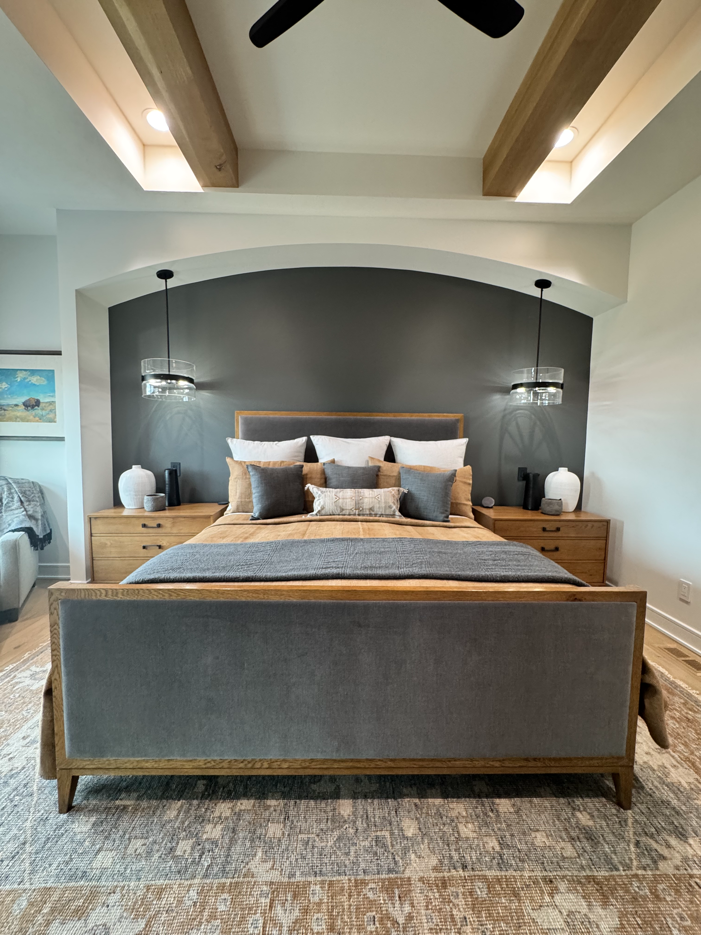 A bedroom with a large bed and a ceiling fan.