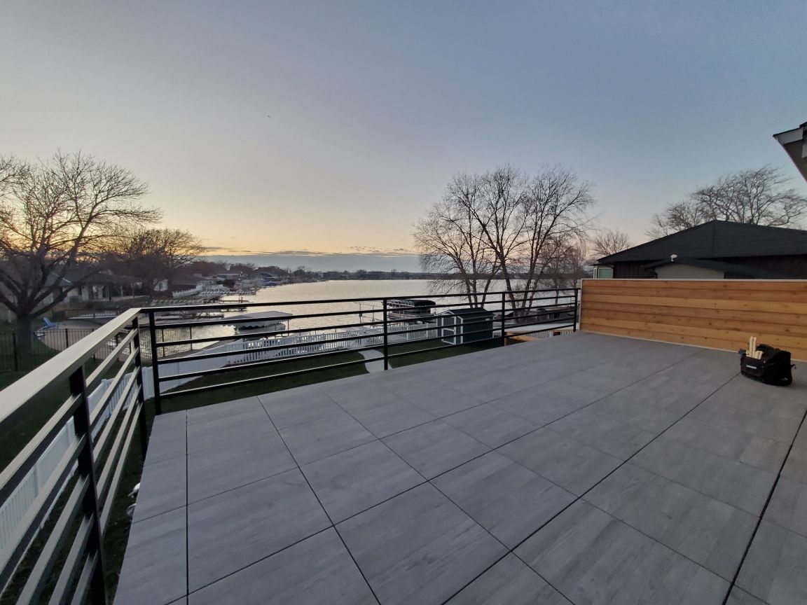 A balcony with a railing overlooking a body of water.