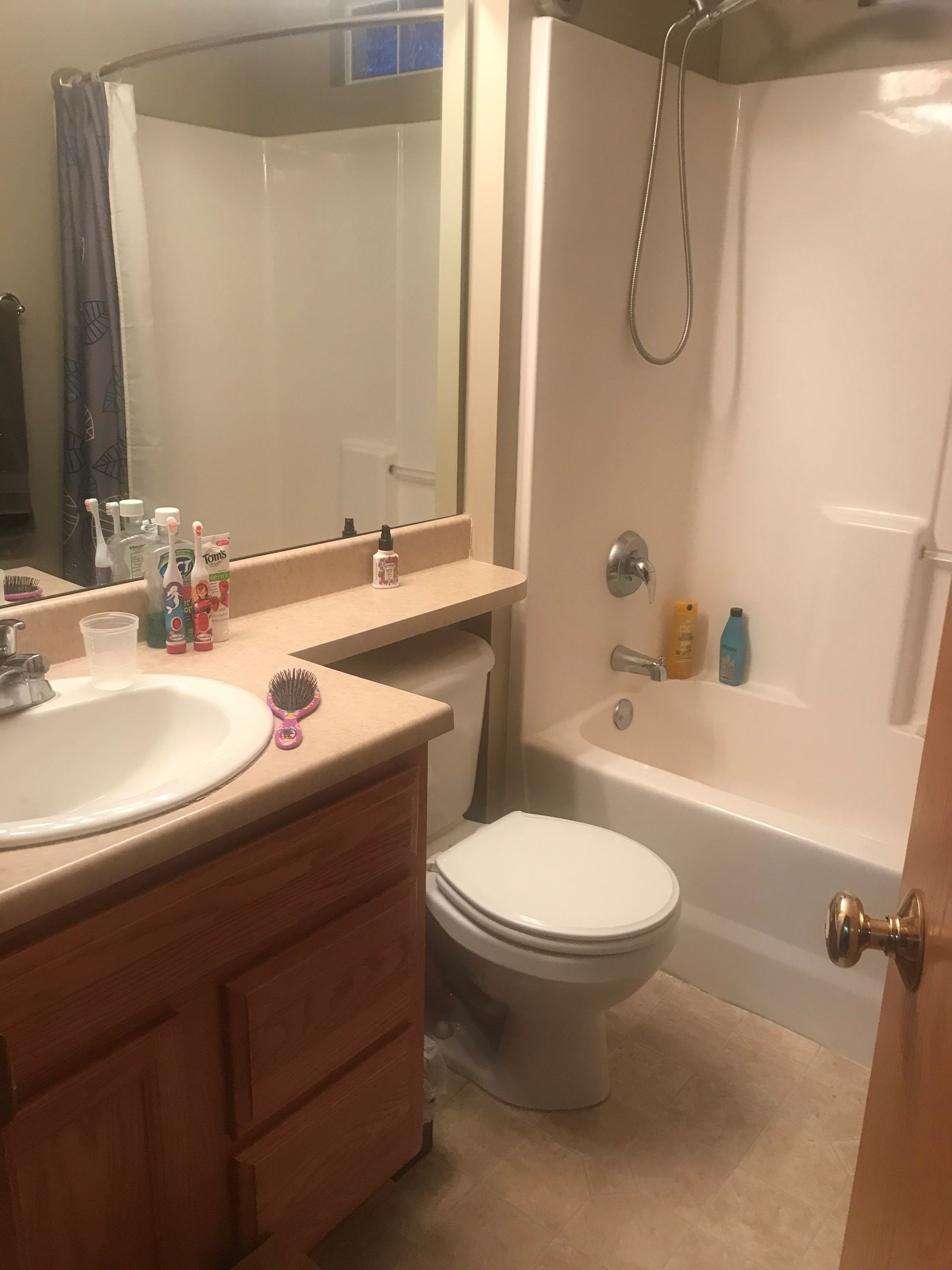 A bathroom with a toilet , sink , tub and shower.