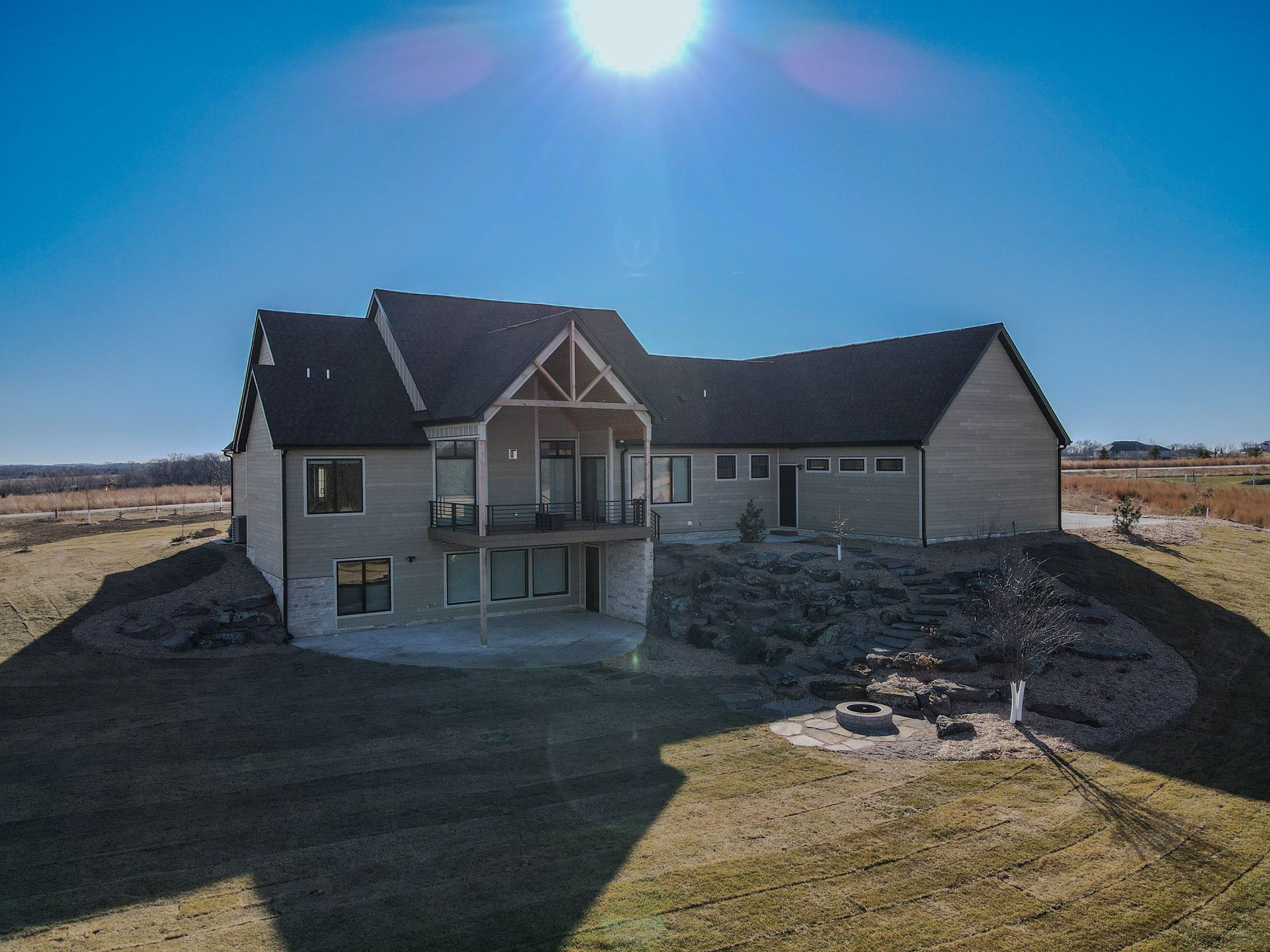 An aerial view of a large house with a fire pit in the backyard.