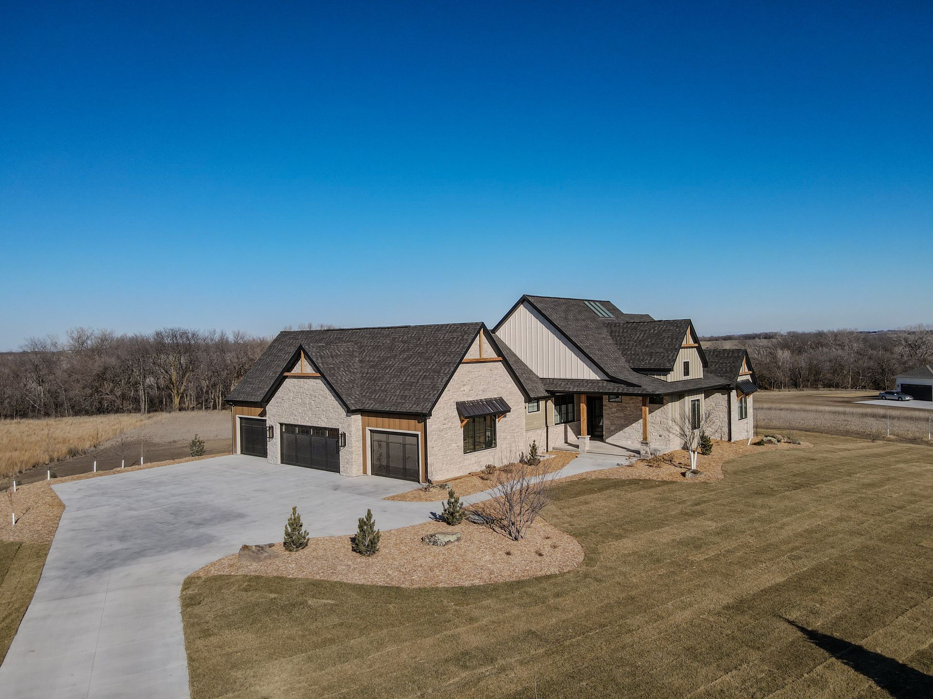 An aerial view of a large house with two garages and a driveway.