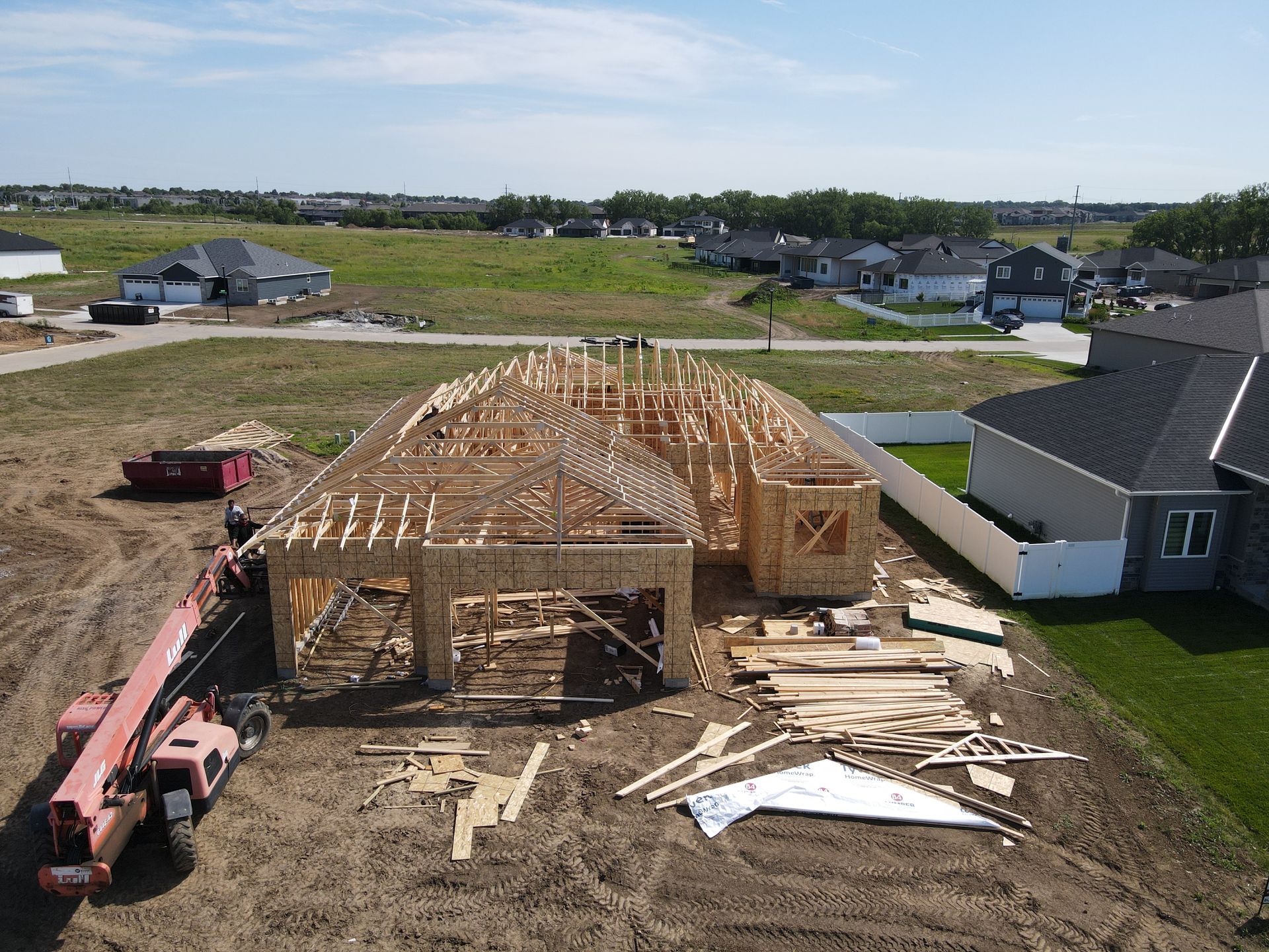 Construction of a new home, framing stage surrounded by a crane and building materials.