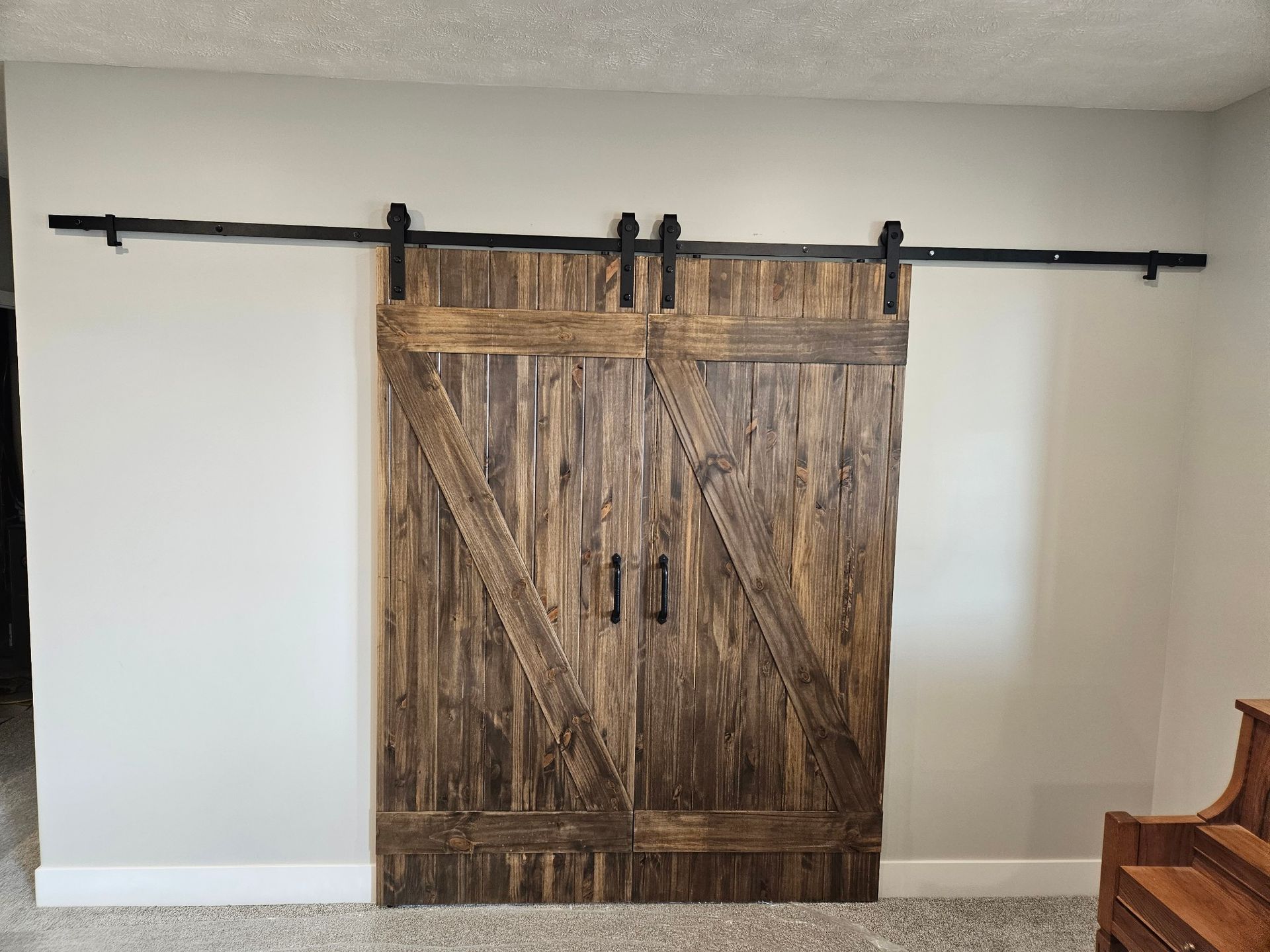 A pair of sliding barn doors are hanging on a wall in a living room.
