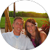 Man and woman smiling, sitting outdoors, sunlight in background.