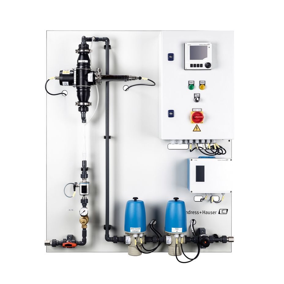 Sistema de tratamiento de agua con tuberías, válvulas, panel de control y componentes azules montados en una pizarra blanca.