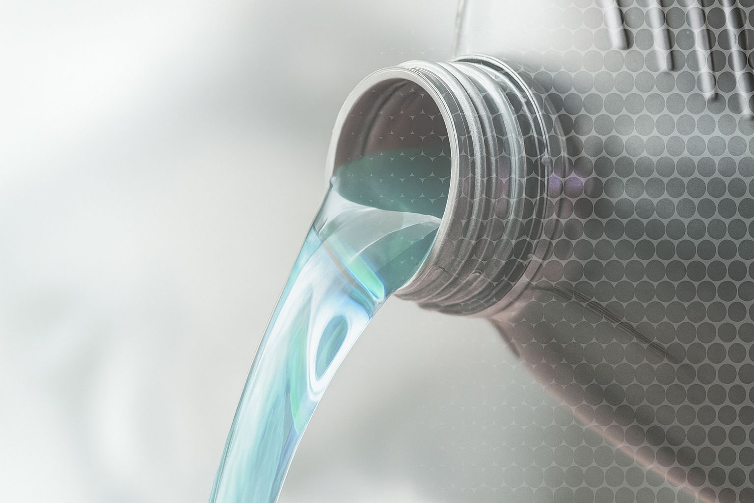 Aceite de motor saliendo de un recipiente gris oscuro.