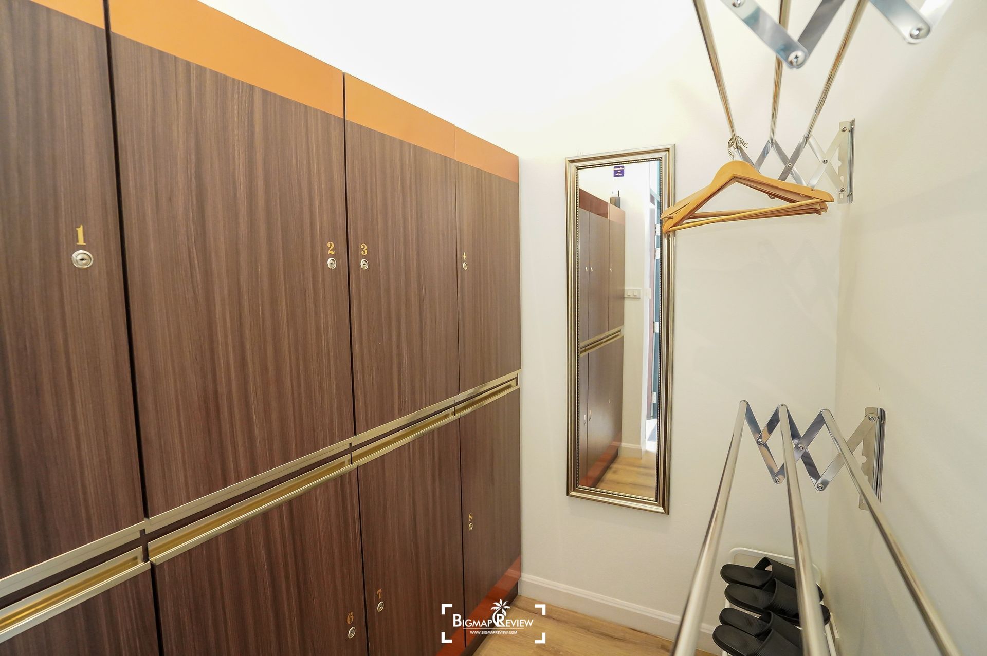 Lockers and a mirror in a locker room with coat rack and wall-mounted drying rack.