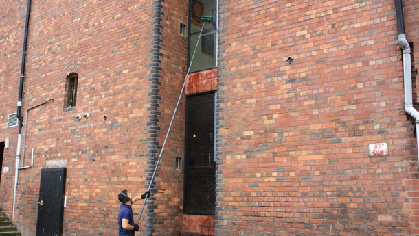 Man cleaning windows with a pole system