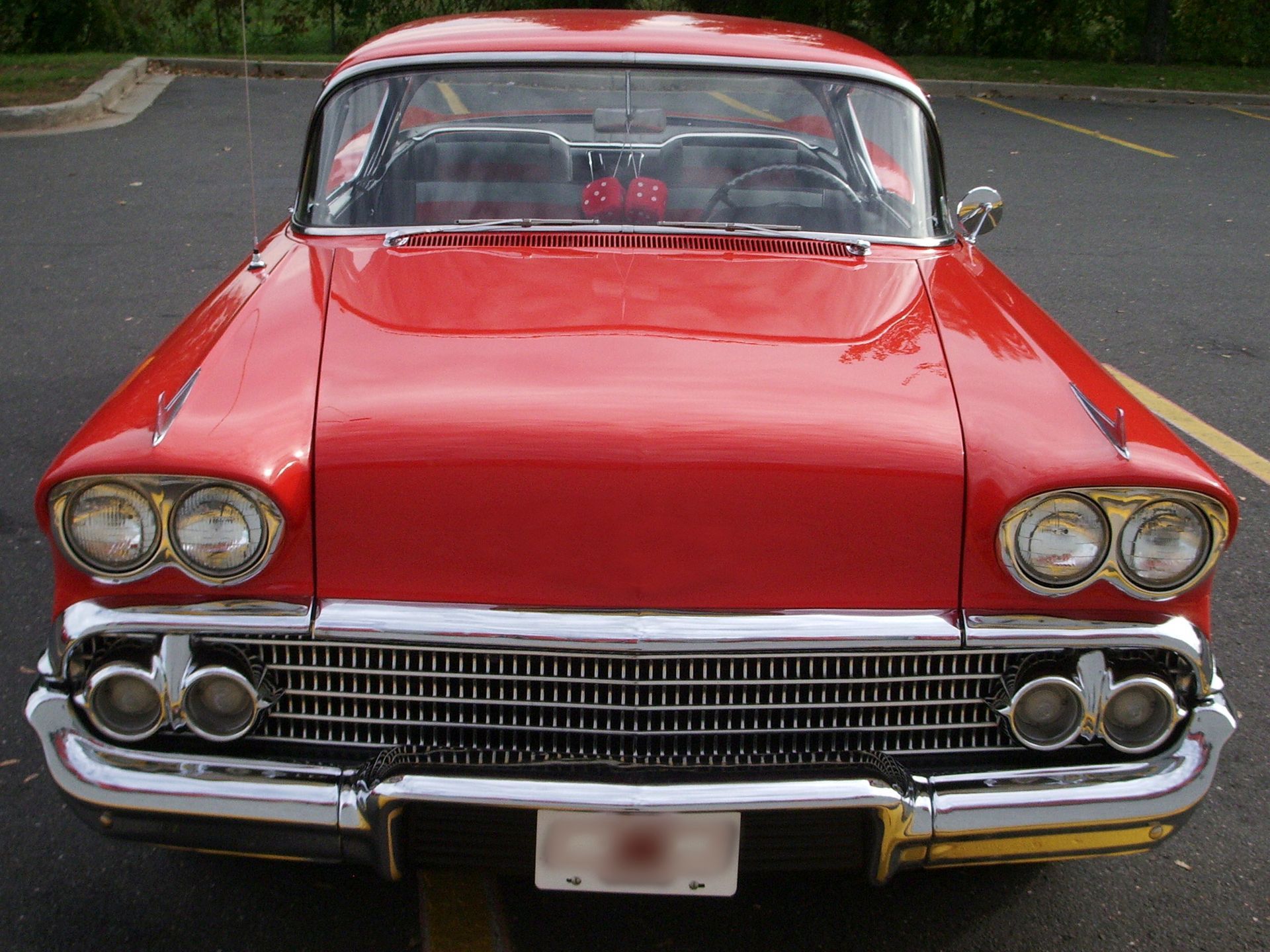A red car is parked in a parking lot