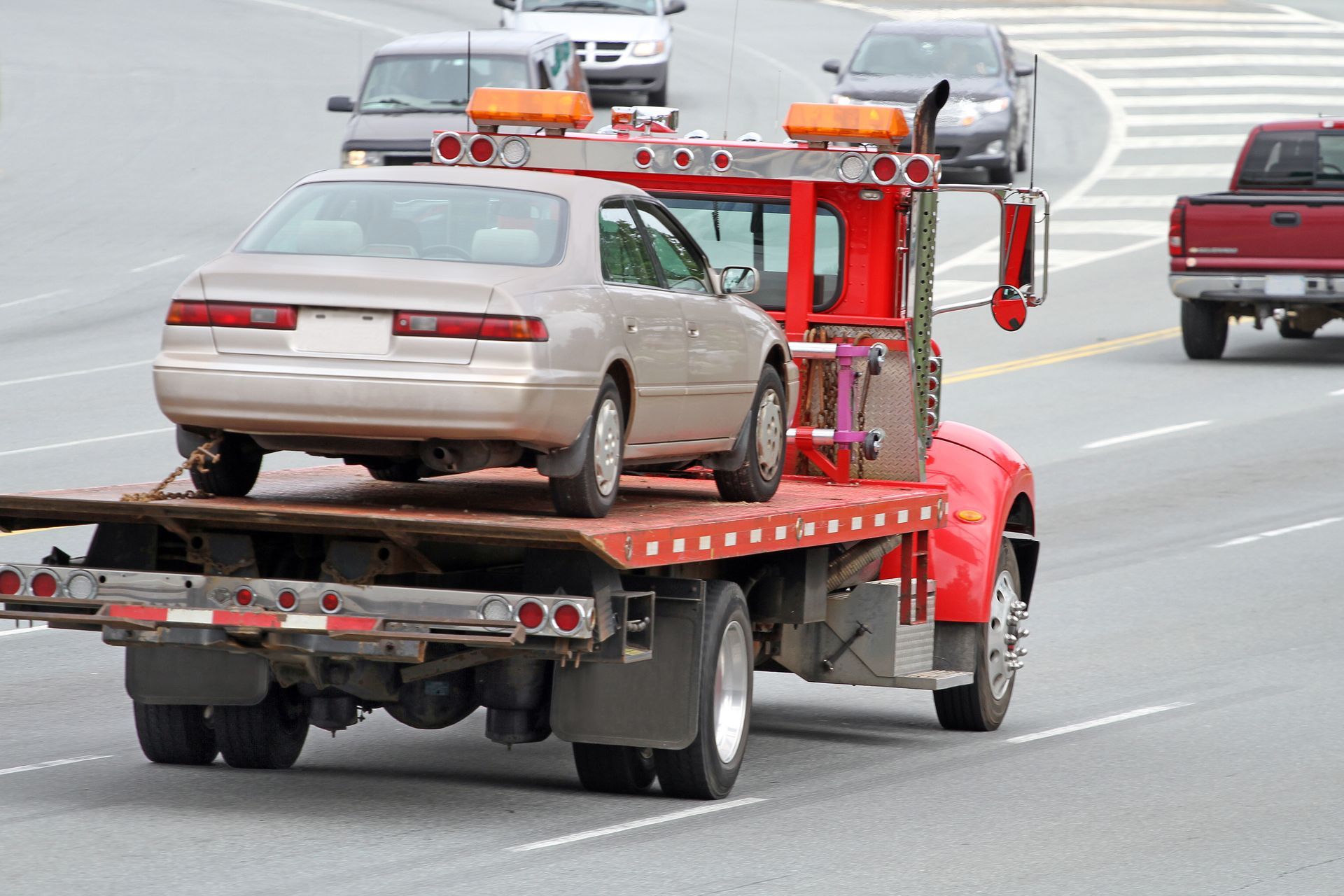 A tow truck with a car on the back of it