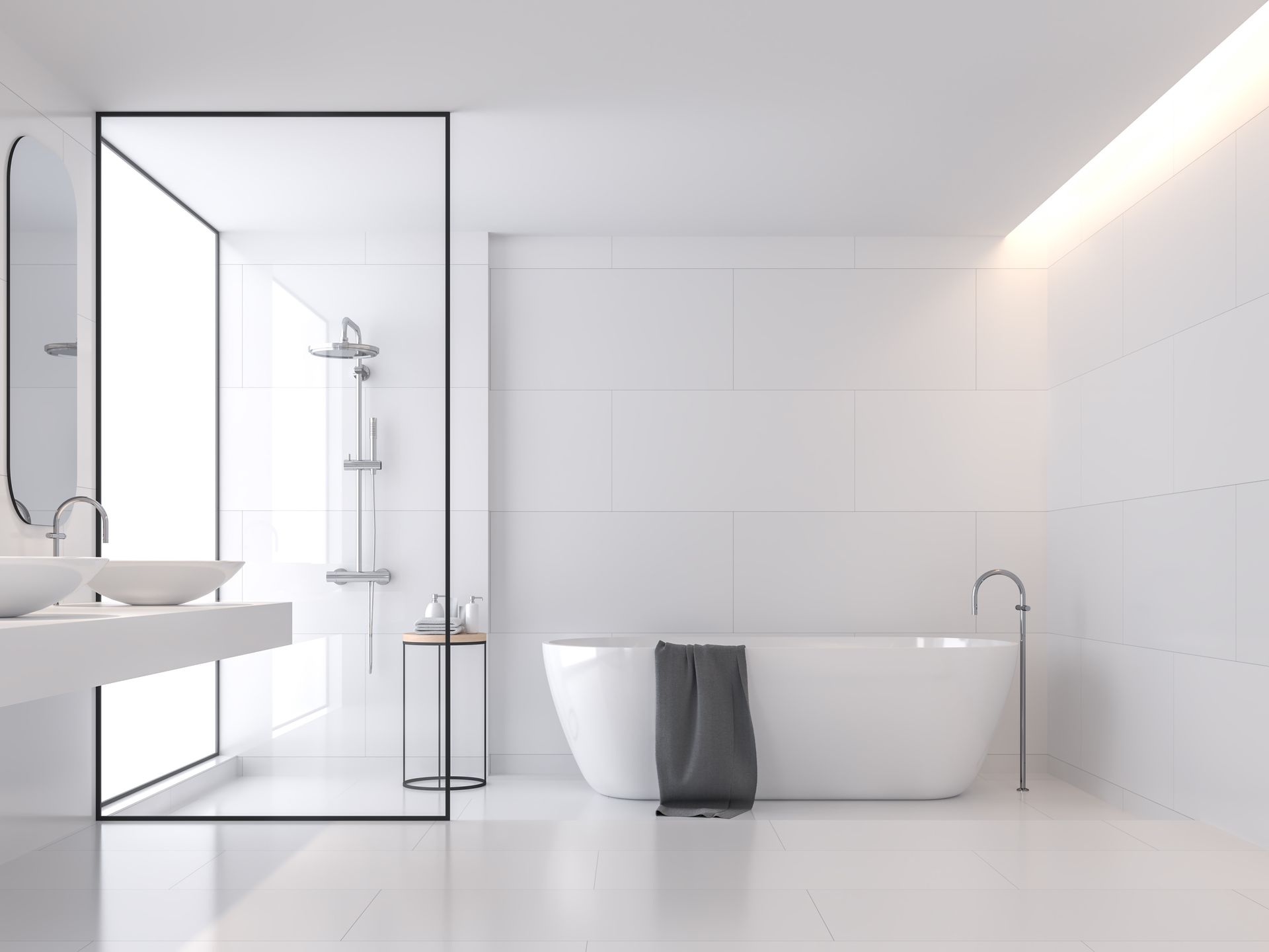 A minimalist, all-white bathroom featuring a freestanding tub with a grey towel and an adjacent glass-enclosed shower.