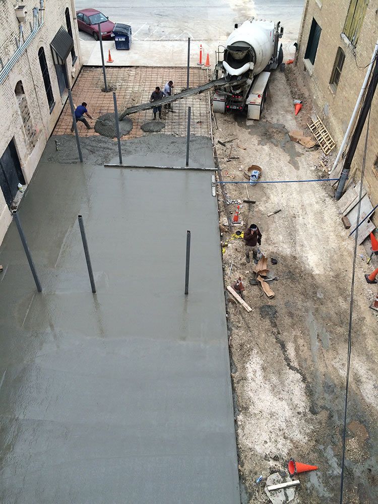 an aerial view of a construction site with a concrete truck pouring concrete .