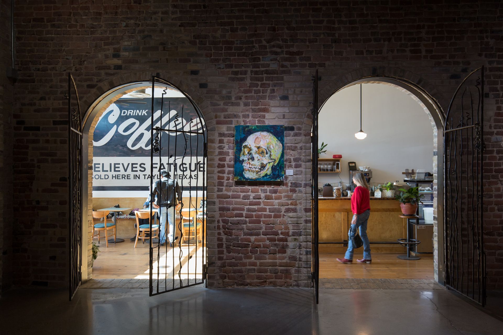a brick building with arches and a painting of a skull on the wall .
