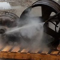 a close up of a machine spraying water on a wooden pallet .