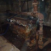 a close up of a rusty pipe in a basement .