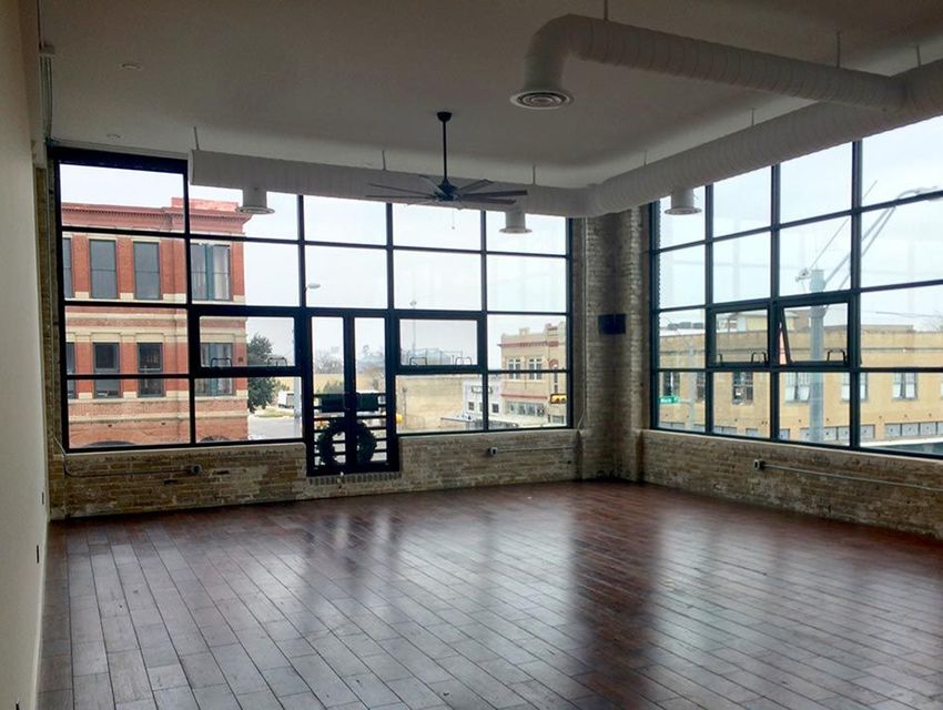 an empty room with a lot of windows and a wooden floor