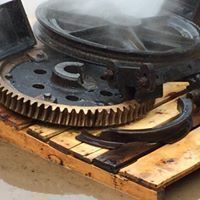 a large gear is sitting on top of a wooden pallet .