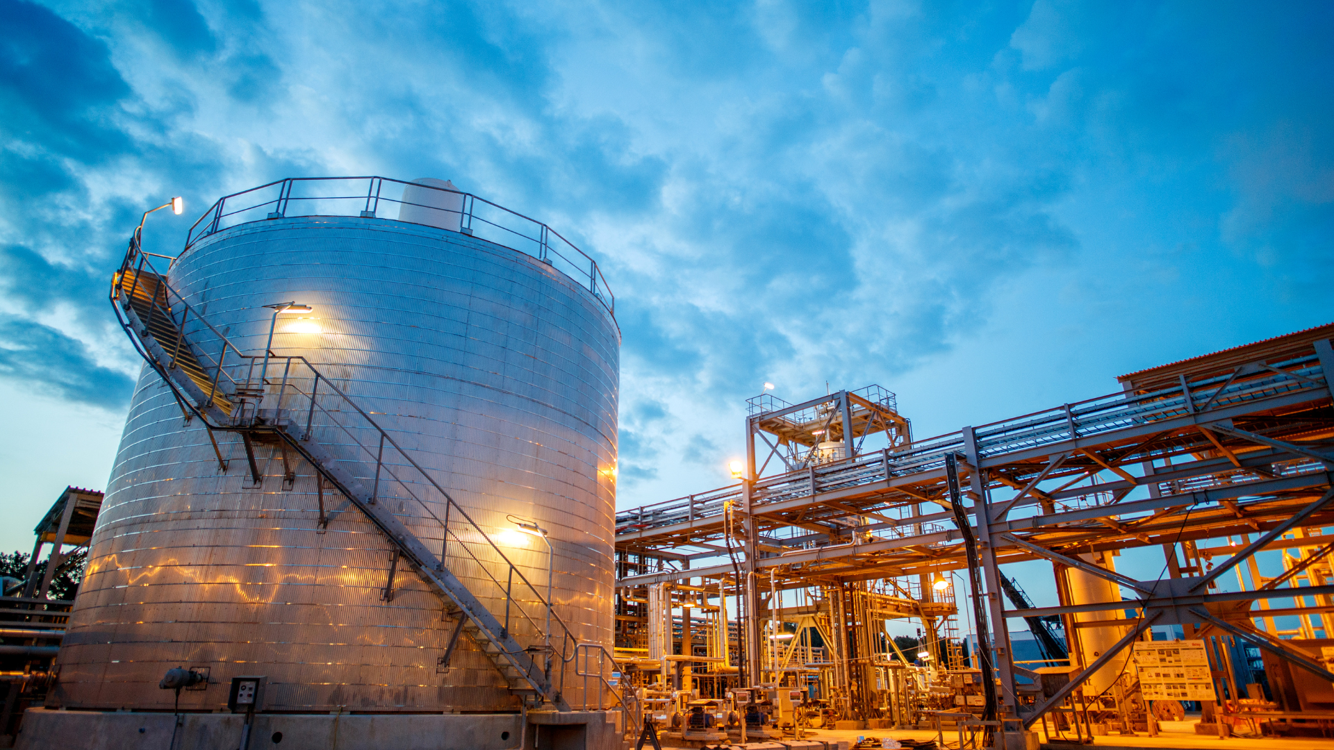 There is a large tank with stairs leading up to it in the middle of a factory.