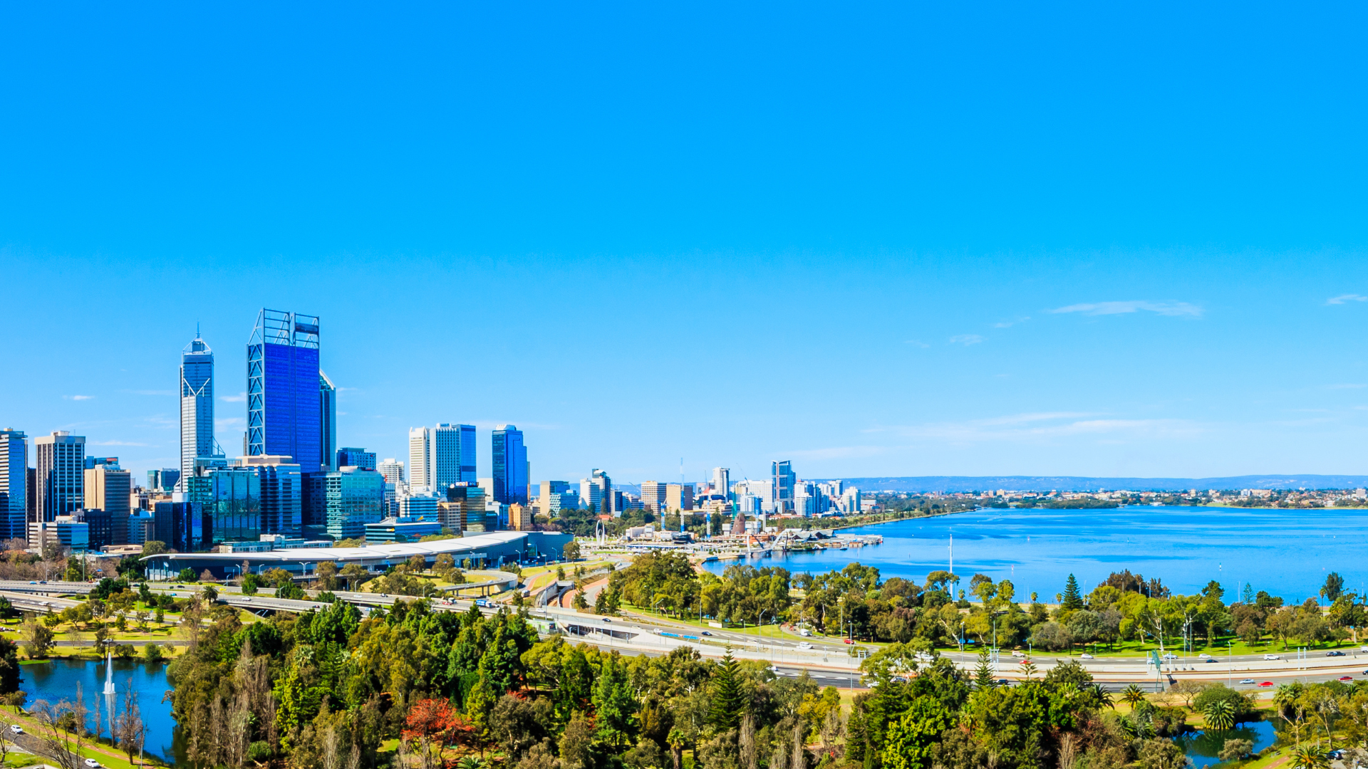 An aerial view of a city skyline with a lake in the foreground.
