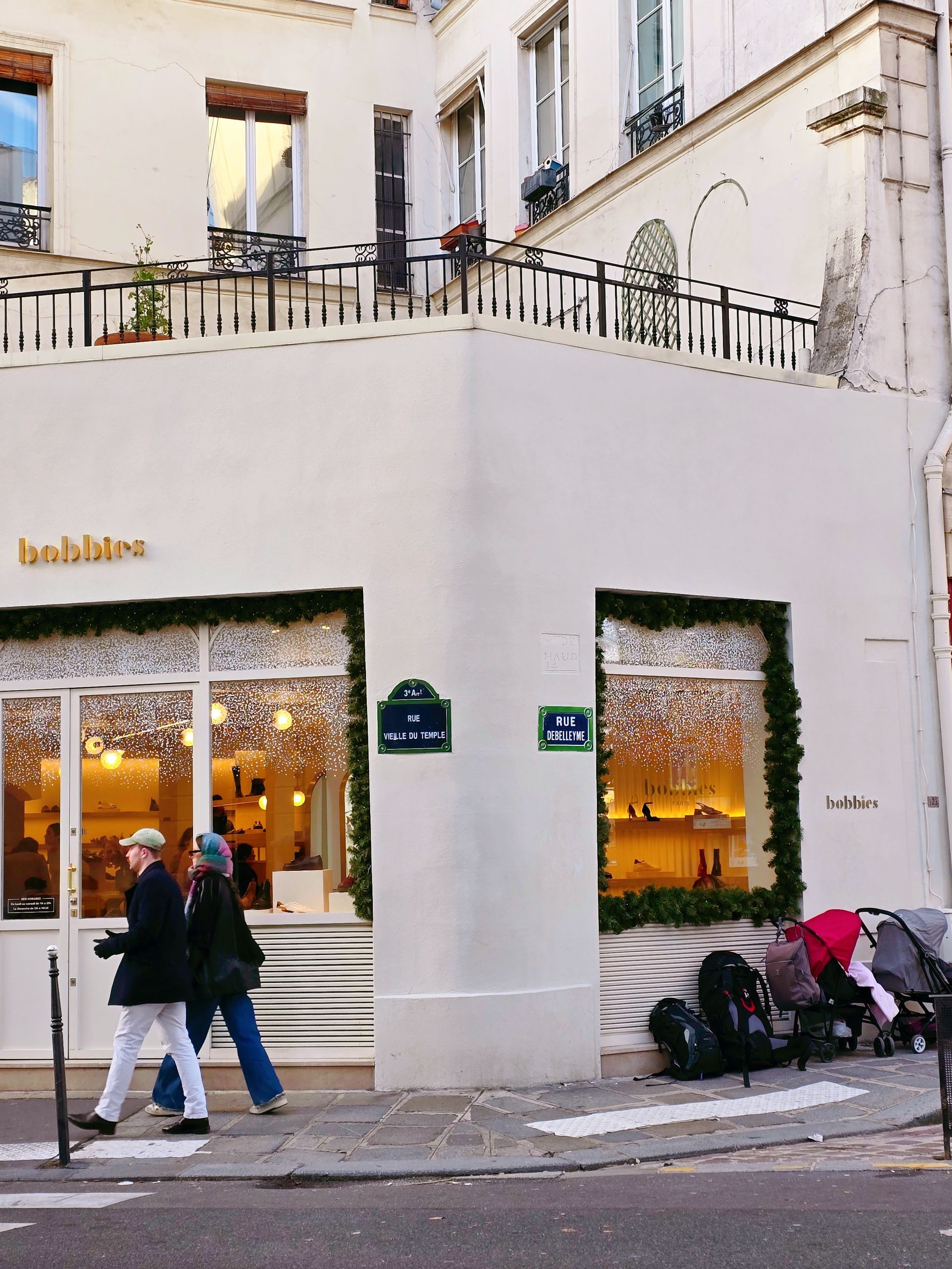 白色建築物的外部視圖，“bobo & mee”的招牌，一個人正在過馬路。