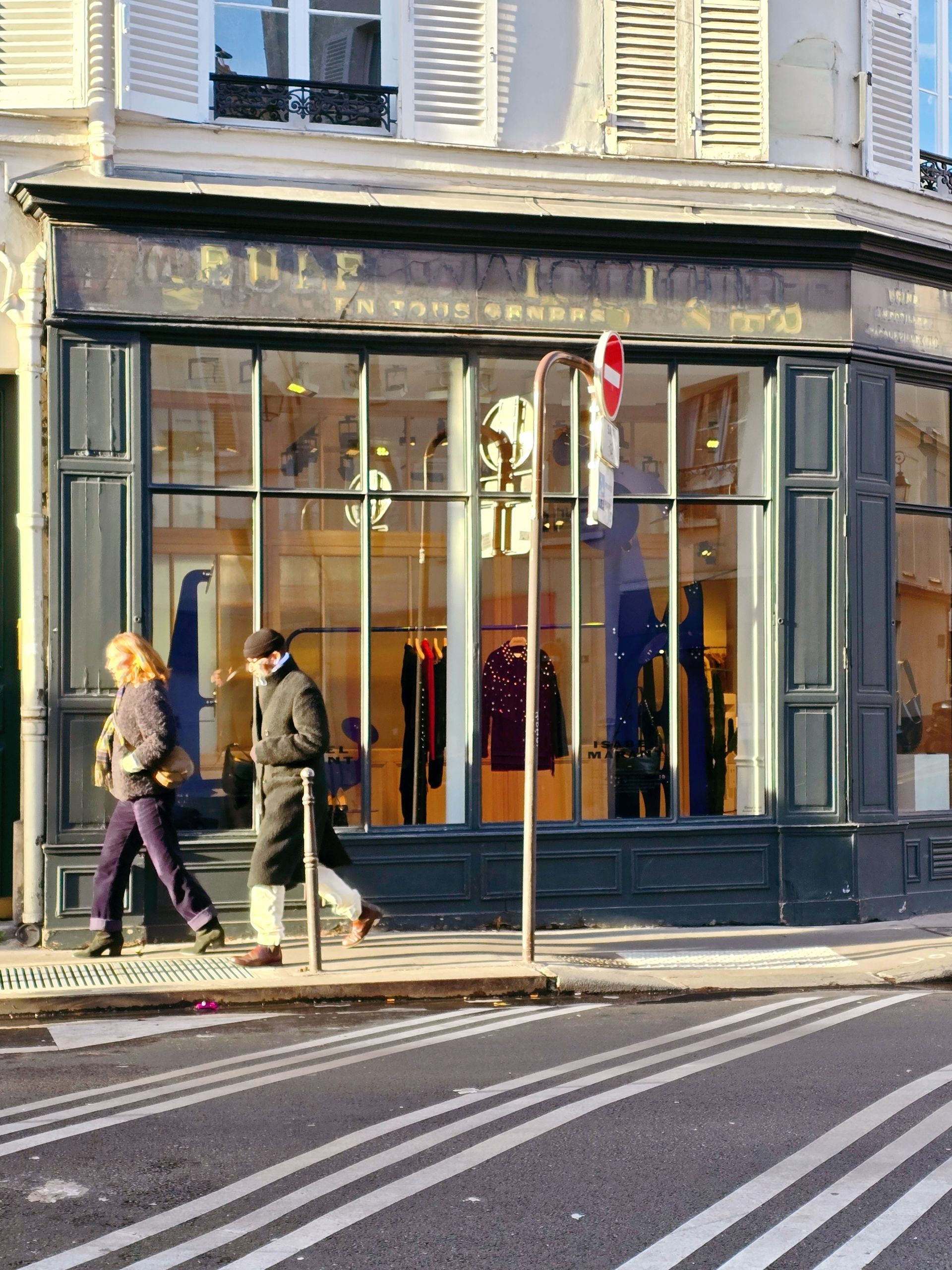 服飾店外，有一條行人穿越道，兩個人從店前走過。