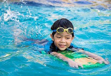 A boy holding a body board — Pool Service in Kansas City, MO