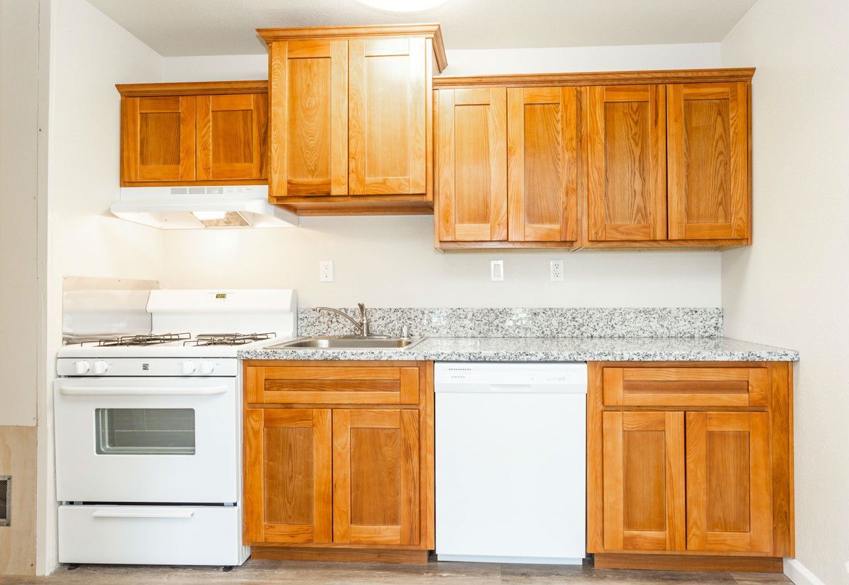 Kitchen with light-colored cabinets, white appliances, and granite countertops.