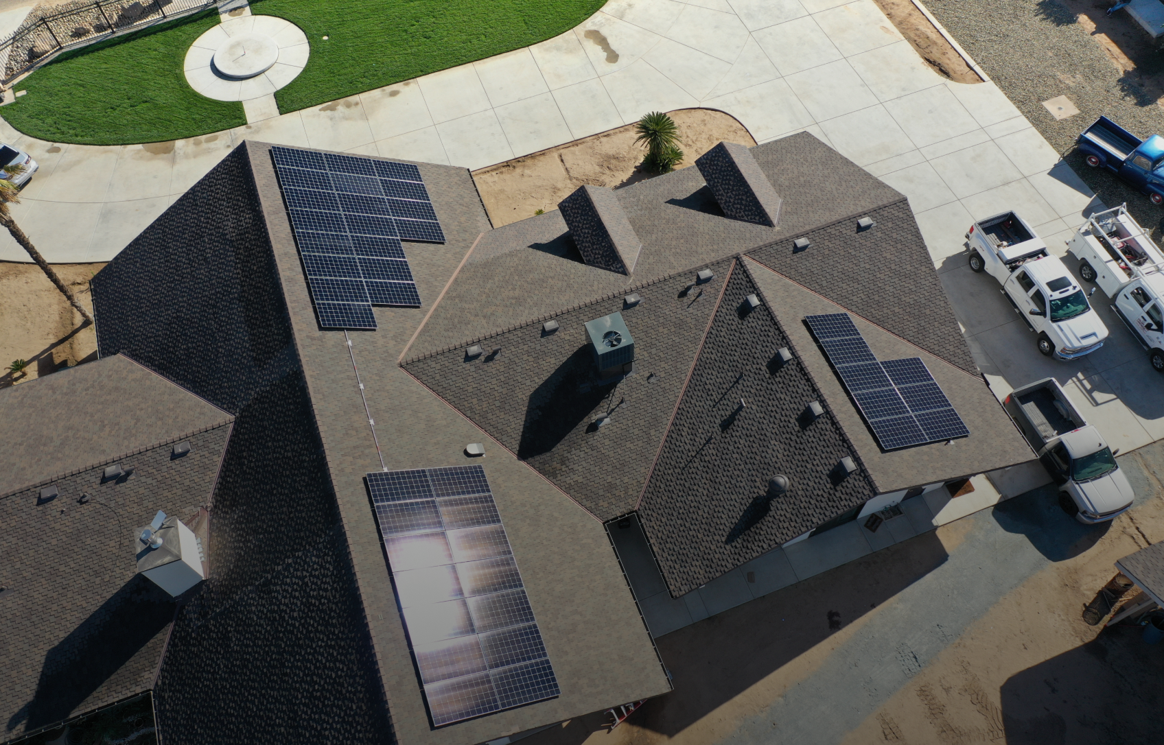 Solar panels installed on a residential roof. Panels are black, roof is dark grey.