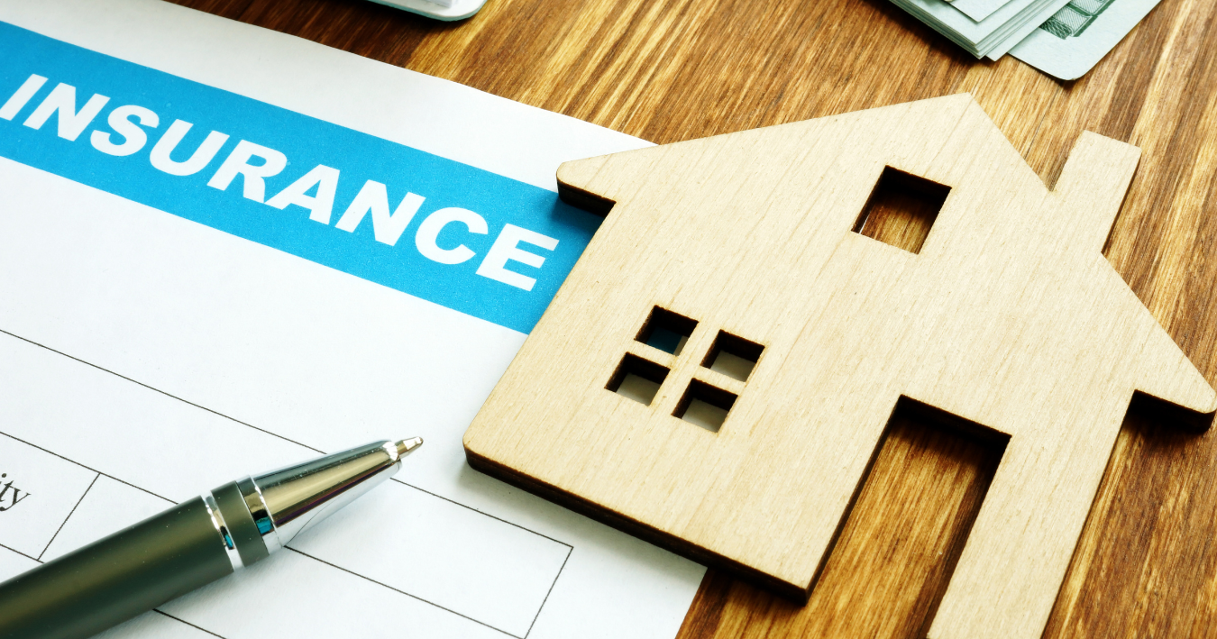 Insurance form with house cutout and pen on a desk