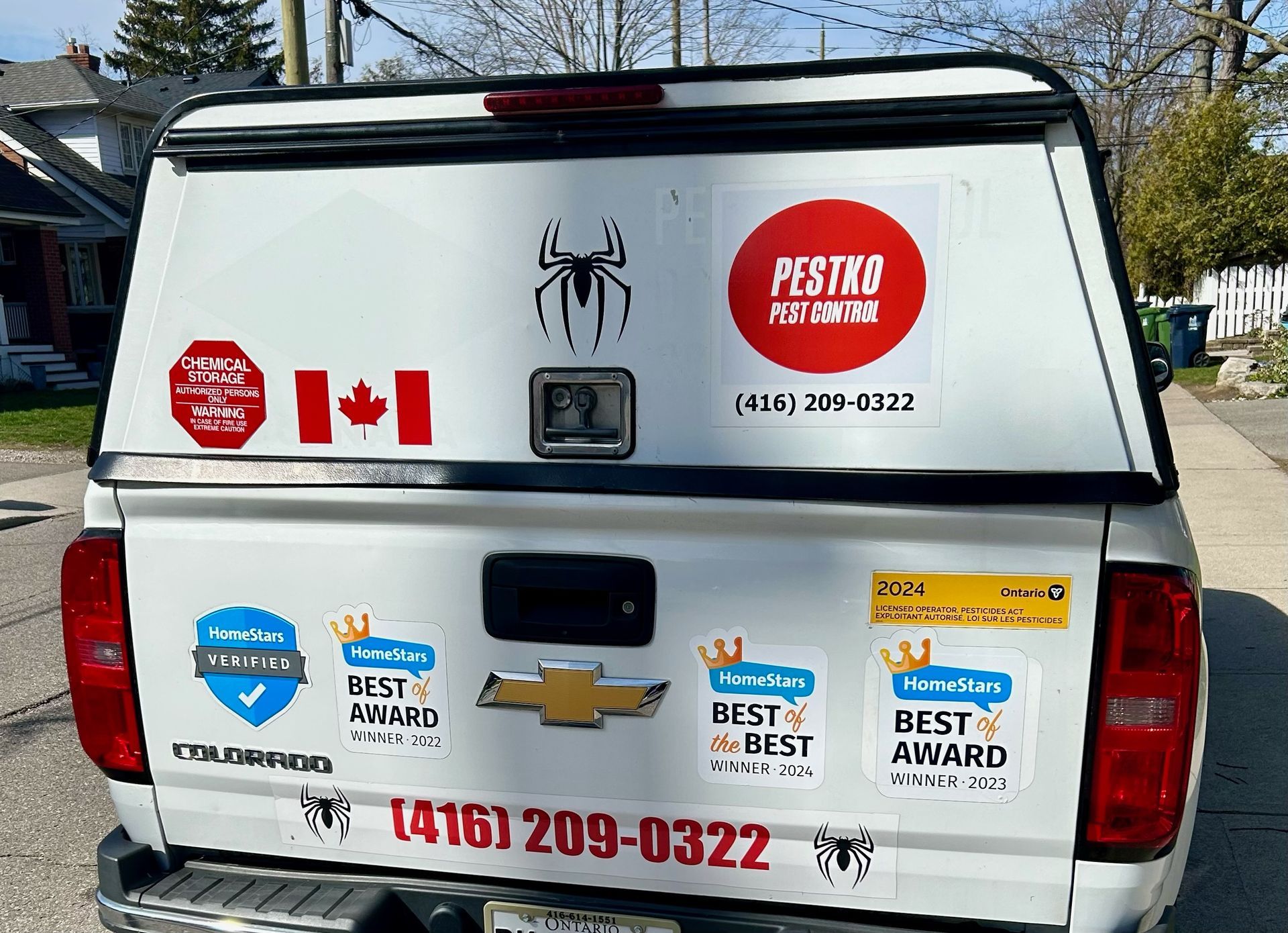 The back of a pest control truck with stickers on it