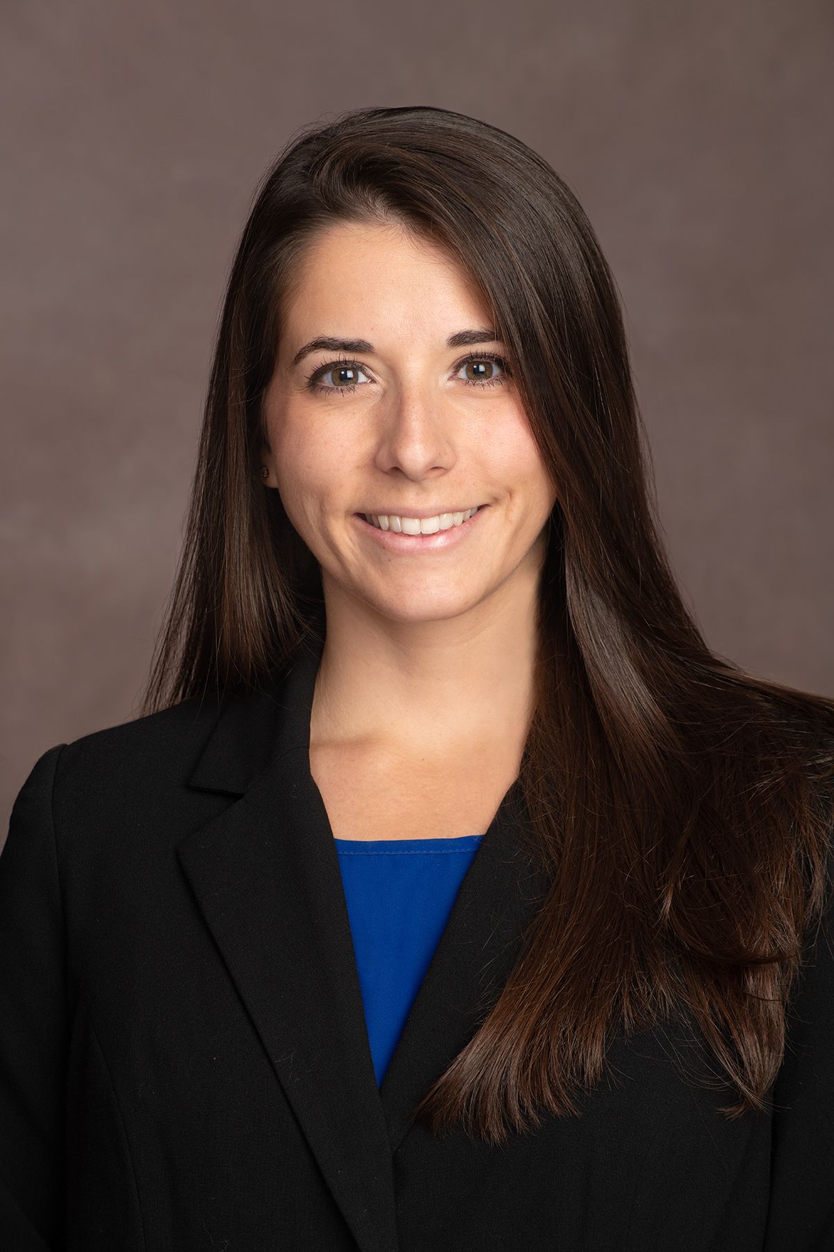 A smiling doctor in a lab coat with a stethoscope around his neck.