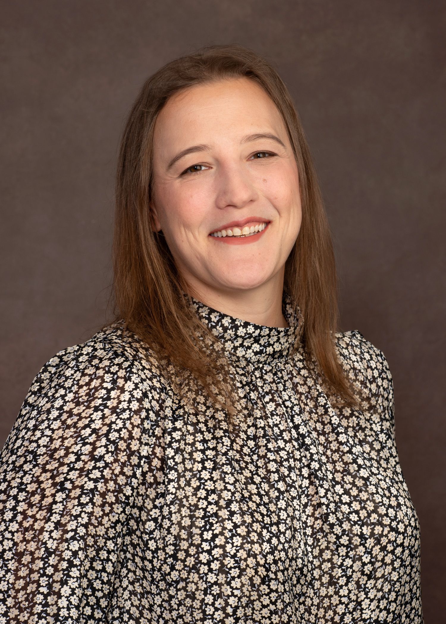 A smiling doctor in a lab coat with a stethoscope around his neck.
