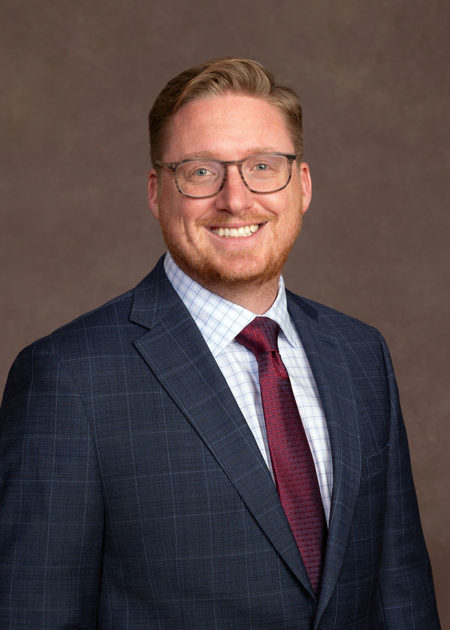 A smiling doctor in a lab coat with a stethoscope around his neck.