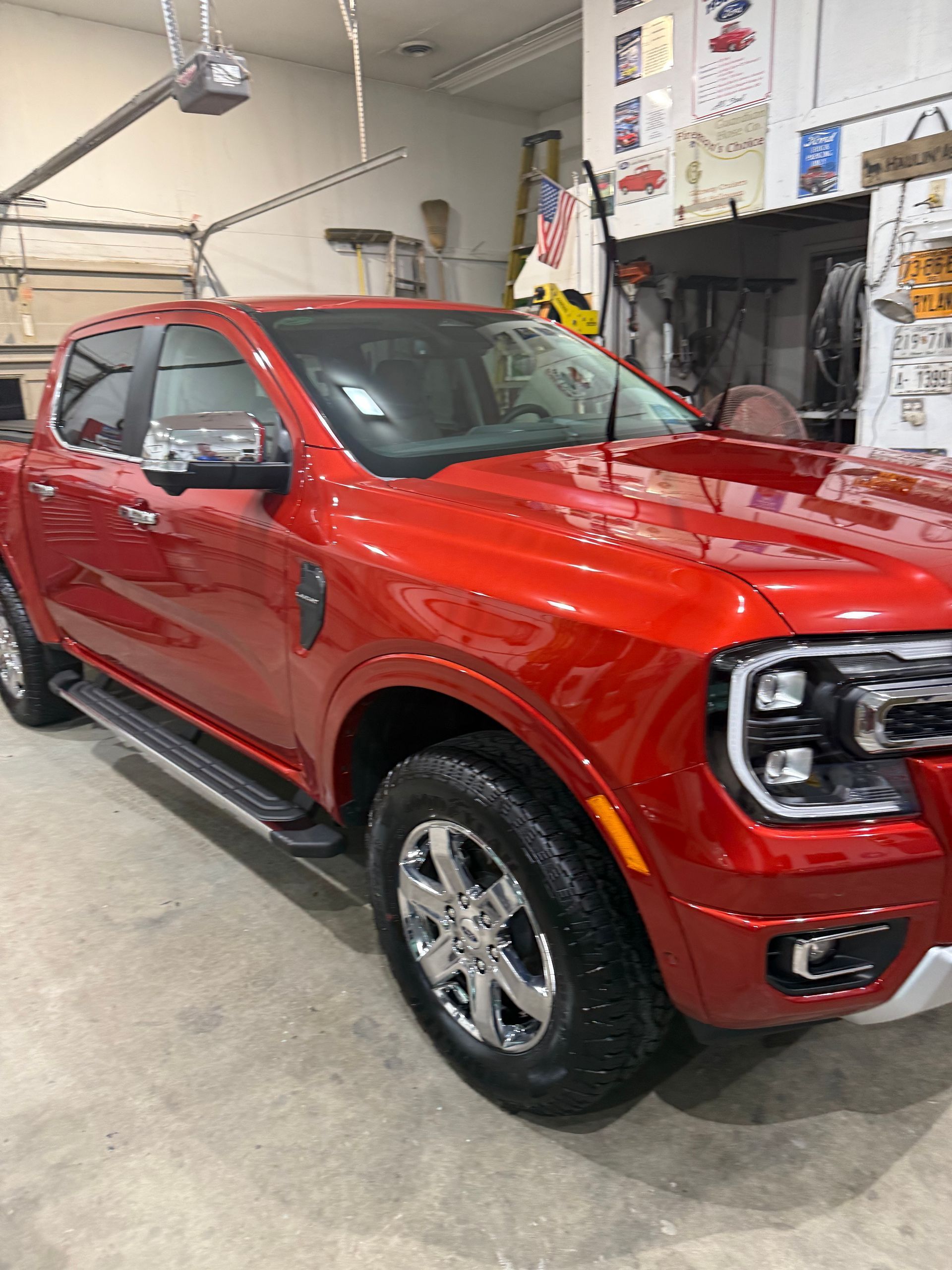 A red pickup truck is parked in a garage.
