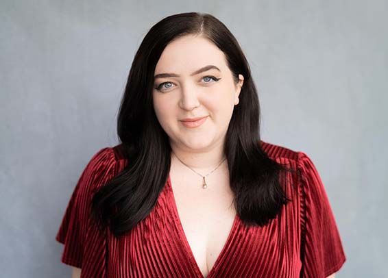 The woman is wearing a red dress and a necklace.