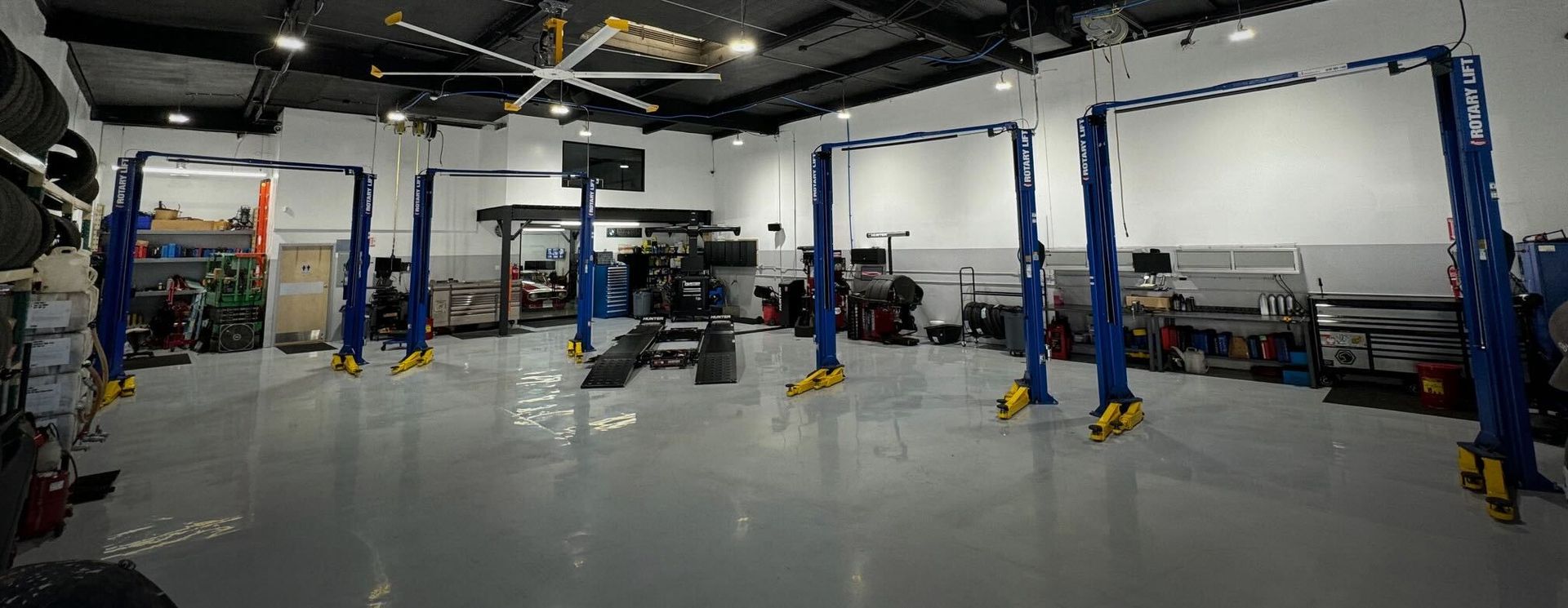 An auto repair shop with multiple vehicle lifts and tools.
