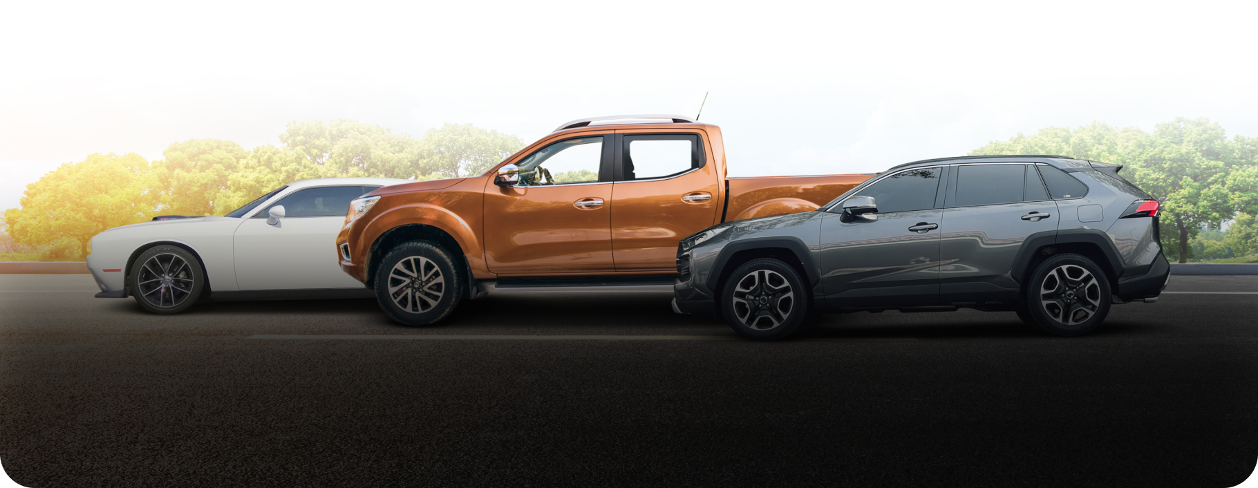 Three vehicles on a road: a white car, an orange pickup truck, and a gray SUV.