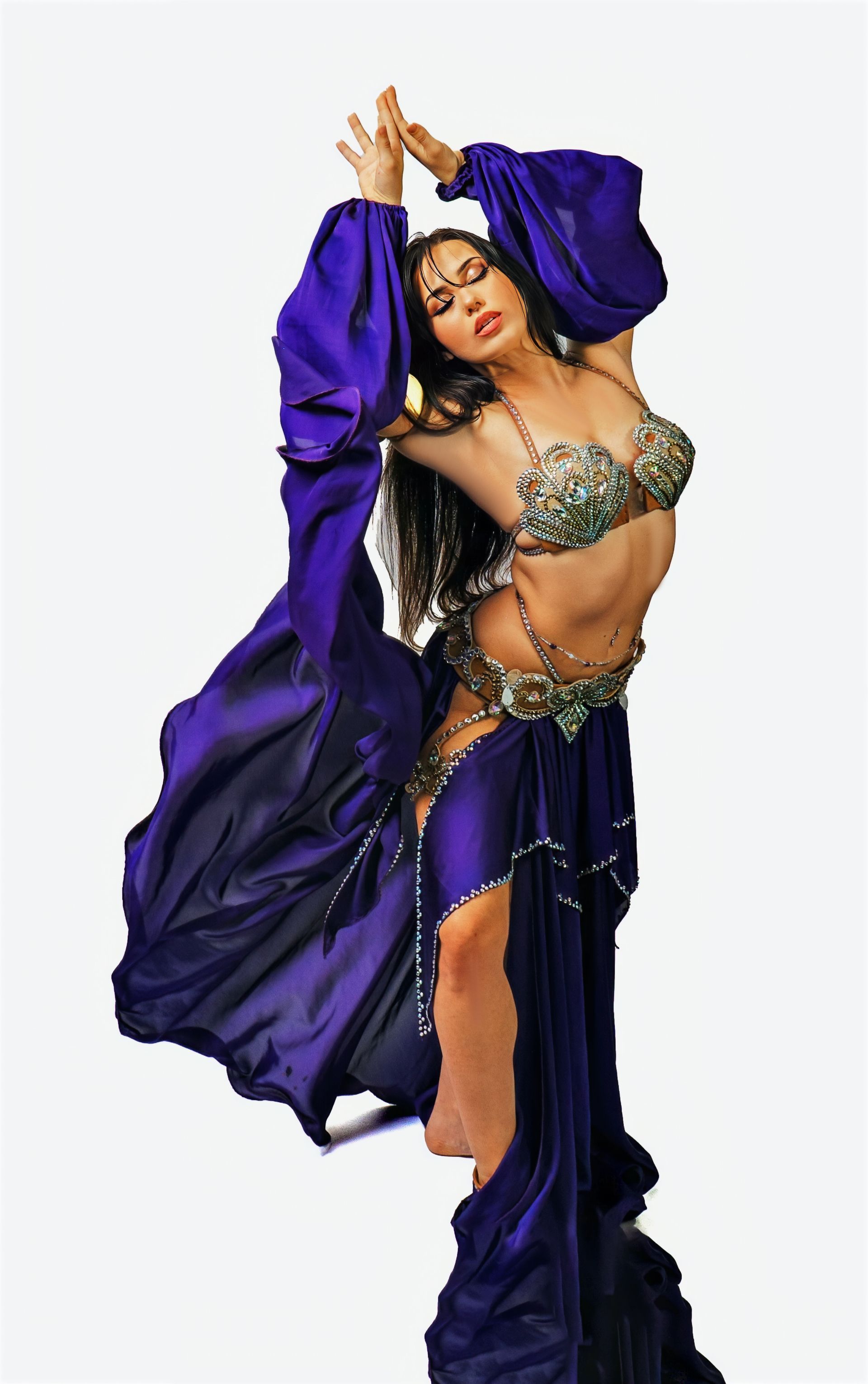 Belly dancer Azeeria Azizah in a purple dress is dancing on a white background