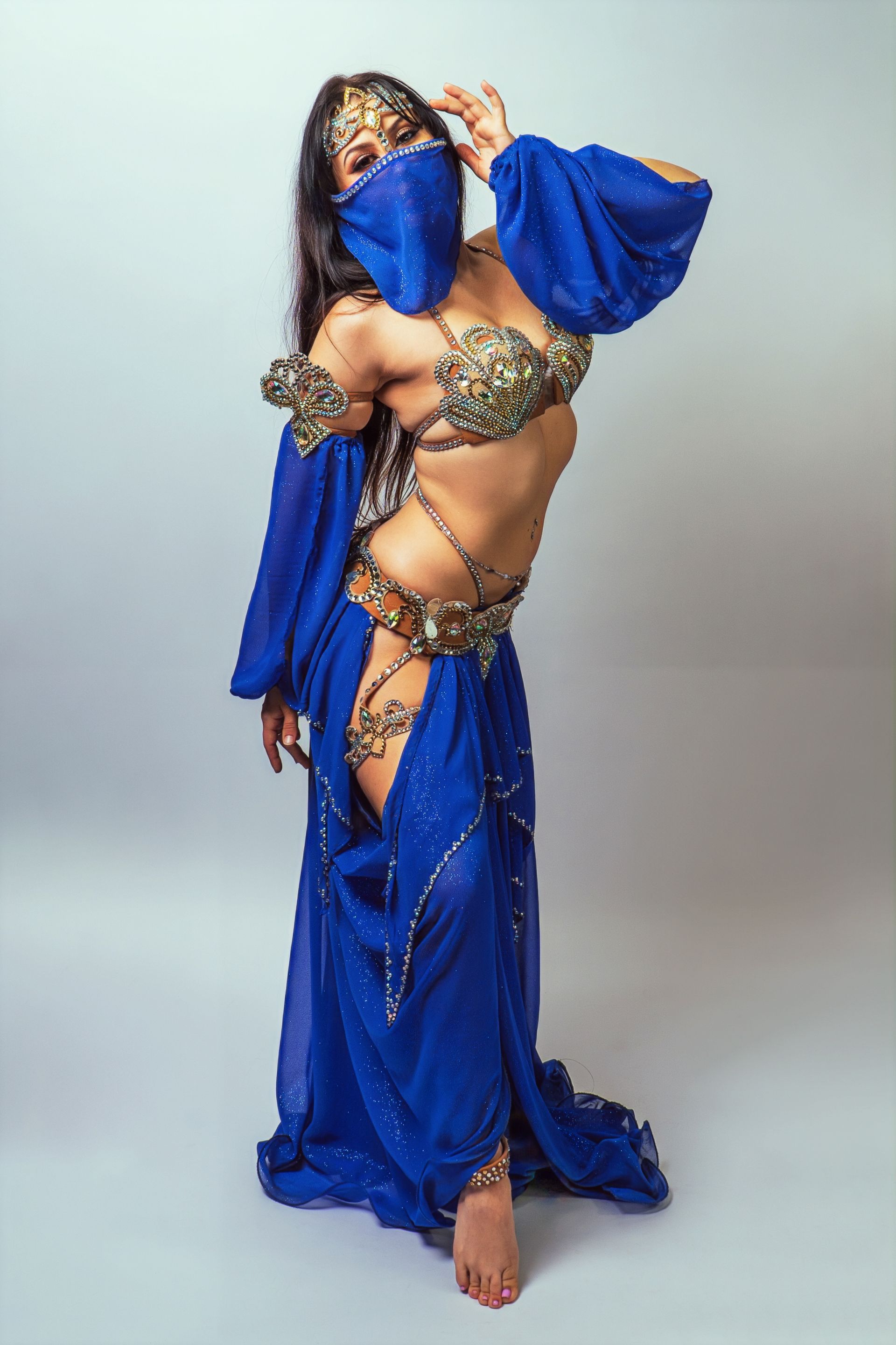 Belly dancer Azeeria Azizah is wearing a blue dress and veil.