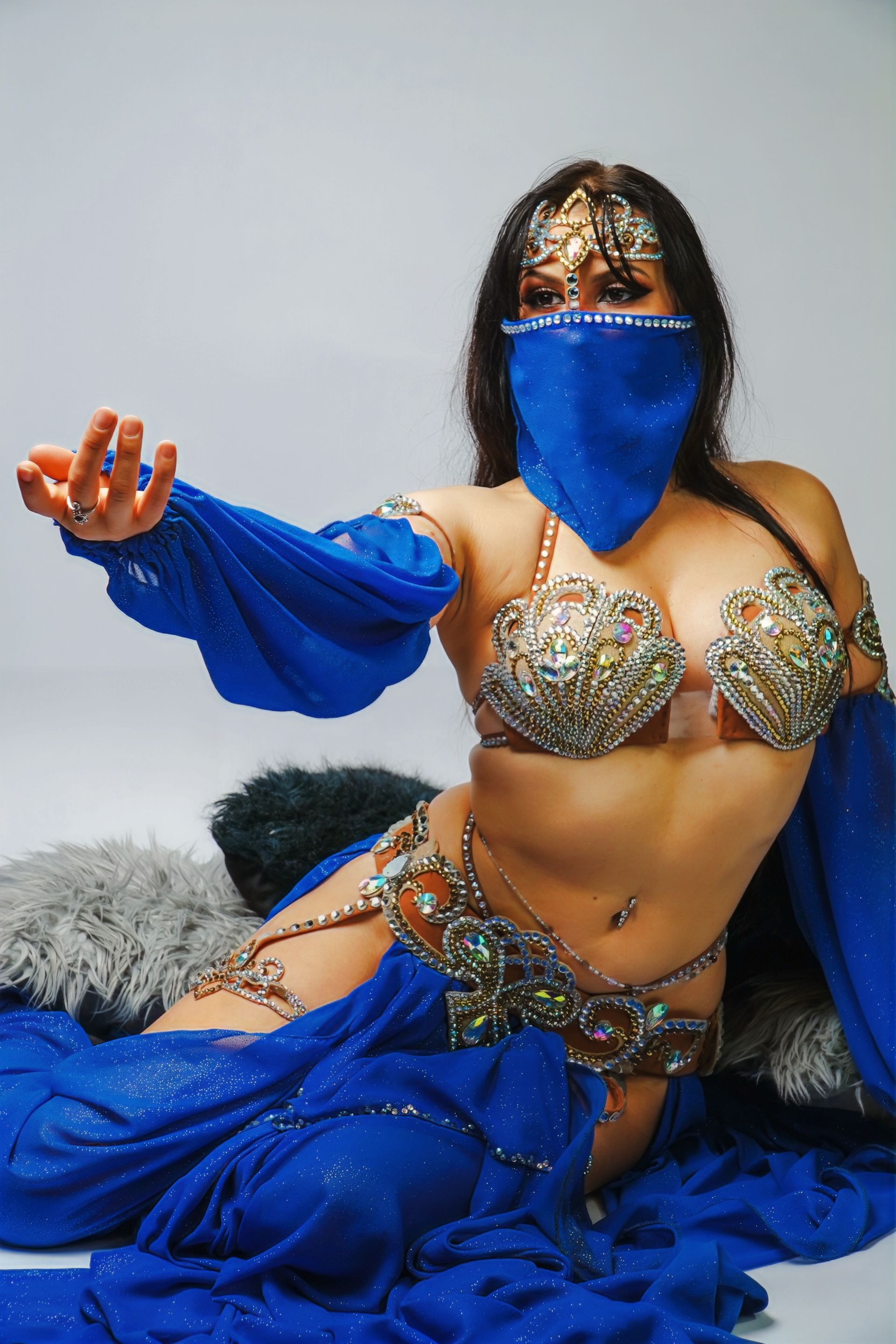 Belly dancer Azeeria Azizah is wearing a blue and gold costume