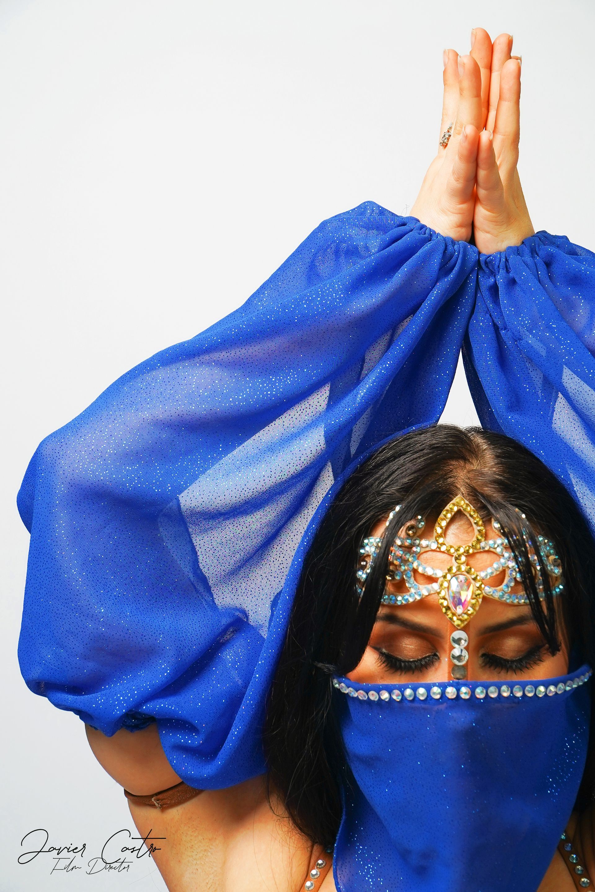 Belly dancer Azeeria Azizah wearing a blue veil and a blue blouse.