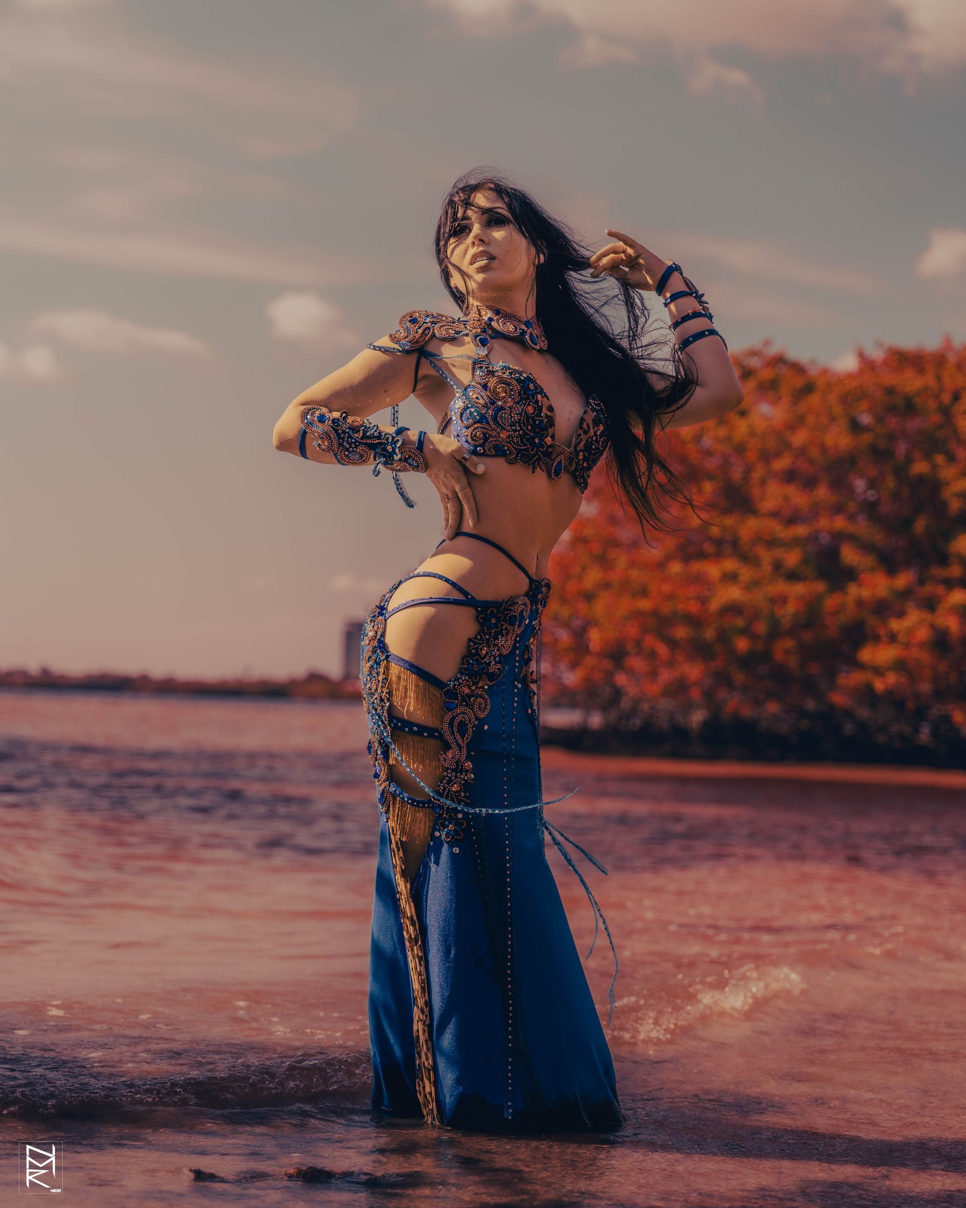 Azeeria Azizah in a belly dancer costume standing in the water.
