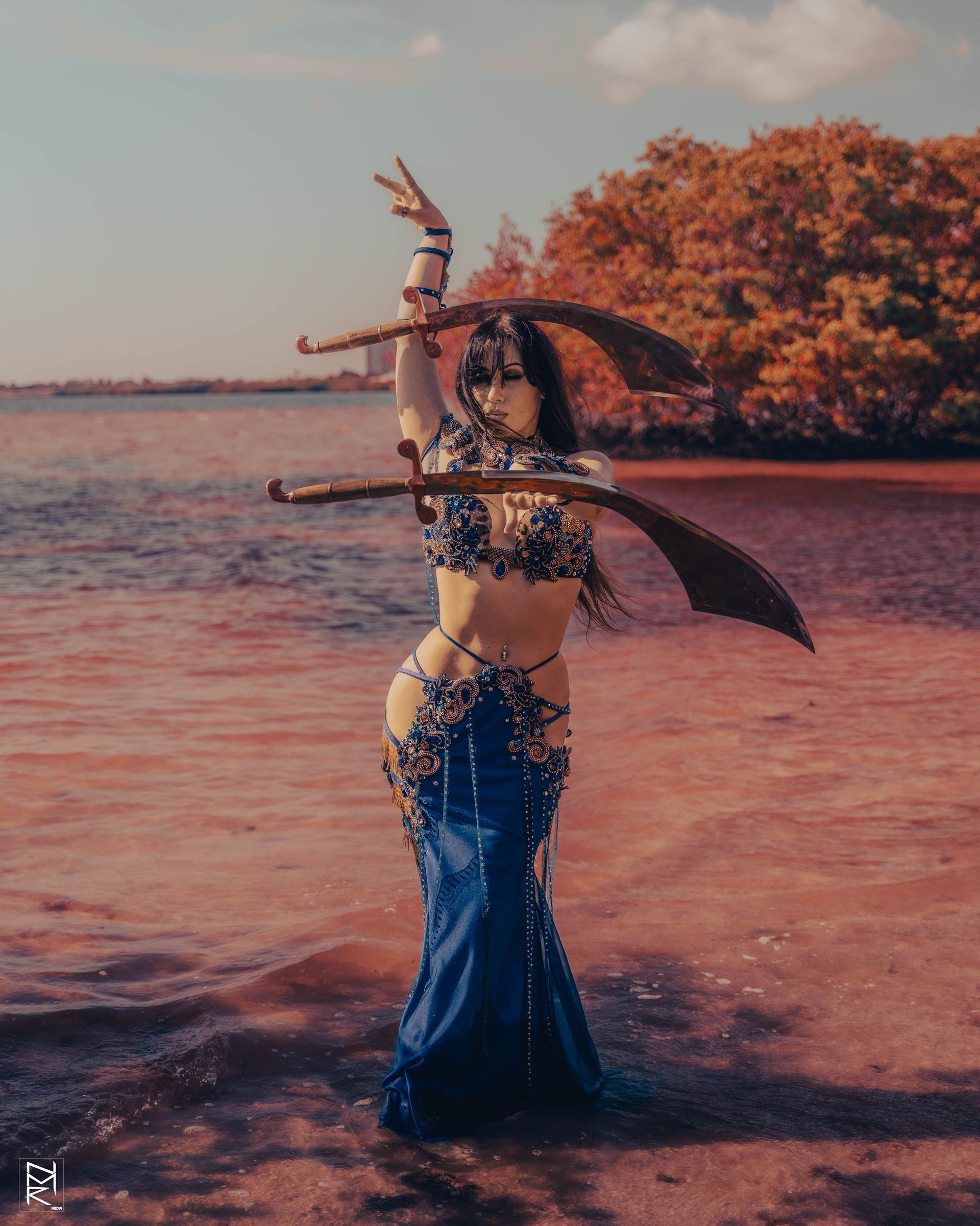 Another shot of the Belly Dancer Azeeria Azizah balancing two swords in the water at cypress beach, Tampa Fl